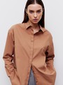 Рубашка oversize, цвет: светло- коричневый Allweneed Рубашка oversize кроя с отложным воротником изастежкой на пуговицы. Длинные рукава с классическими манжетами. Слегка удлиненная спинка. Носите навыпуск или заправленной в контрастную юбку, шорты или брюки.