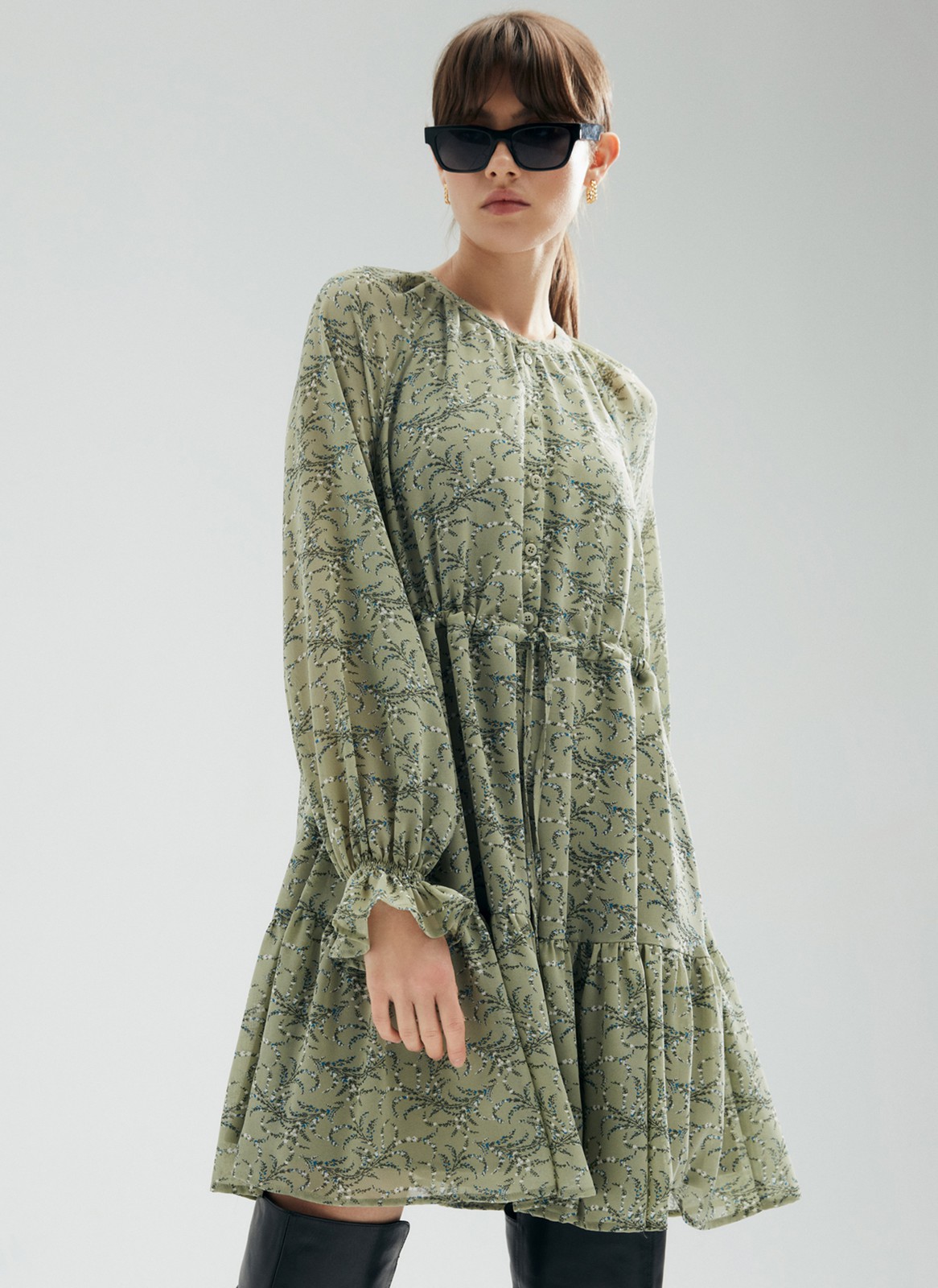 Платье-мини с ярусами, цвет: оливковый Allweneed
Платье-мини из легкого шифона с нежным цветочным принтом. Модель на хлопковой основе, поэтому в ней комфортно и весной, и летом. Свободное платье с ярусами можно затянуть шнурочком из собственной ткани. Воротник лежащая стойка и застежка с пуговицами до линии талии. Воздушные рукава и нижний ярус со сборками. На рукаве есть тонкая резиночка для фиксации. Нам уже не терпится закружиться в платье среди цветов и деревьев.
На модели размер XS\S