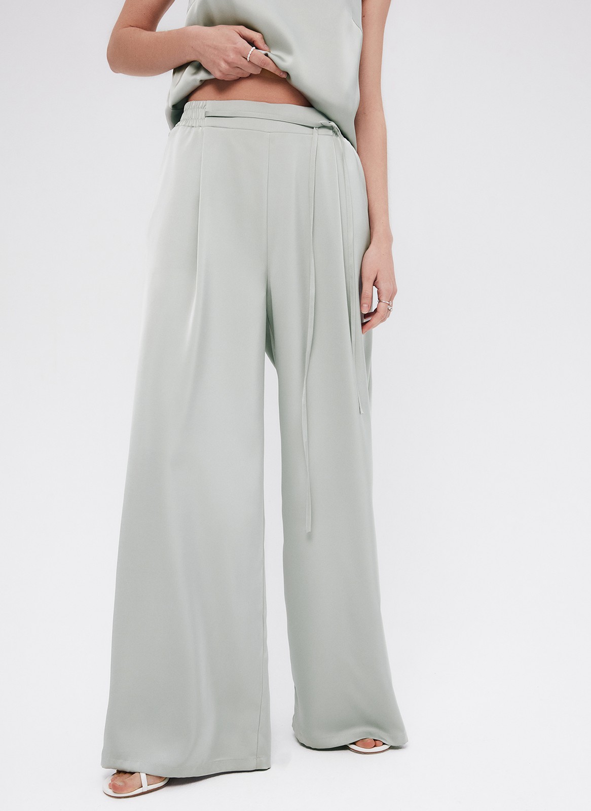Брюки палаццо, цвет: мятный Allweneed
Легкие брюки свободного кроя из ткани атласного переплетения. Ткань струится и переливается при ходьбе, но неприхотлива в уходе. Широкий пояс с резинкой, декоративный шнурок на поясе, глубокие складки на передней части брюк. Удобные карманы. Вы можете добавить по желанию изящные босоножки или удобные кеды, футболку oversize или топ с открытой спиной. Можно составить комплект с рубашкой и топом из нашей коллекции.
На модели размер XS