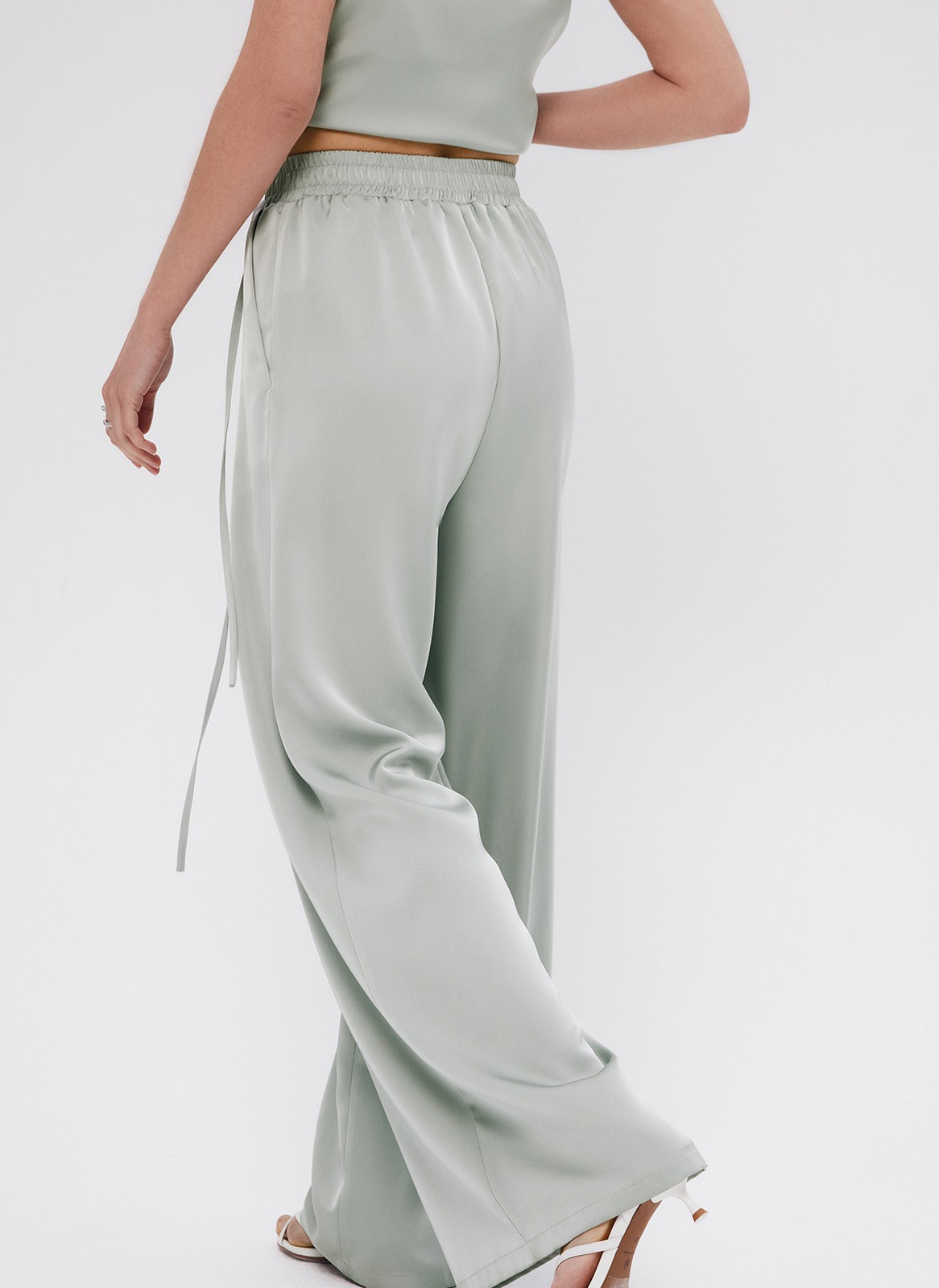 Брюки палаццо, цвет: мятный Allweneed
Легкие брюки свободного кроя из ткани атласного переплетения. Ткань струится и переливается при ходьбе, но неприхотлива в уходе. Широкий пояс с резинкой, декоративный шнурок на поясе, глубокие складки на передней части брюк. Удобные карманы. Вы можете добавить по желанию изящные босоножки или удобные кеды, футболку oversize или топ с открытой спиной. Можно составить комплект с рубашкой и топом из нашей коллекции.
На модели размер XS
