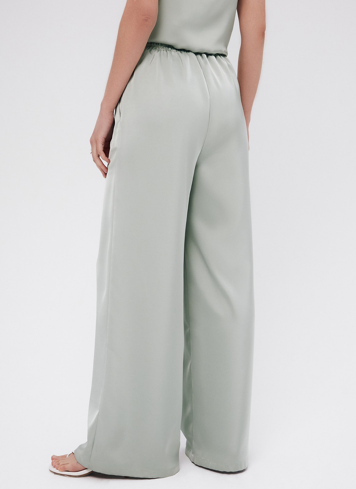 Брюки палаццо, цвет: мятный Allweneed
Легкие брюки свободного кроя из ткани атласного переплетения. Ткань струится и переливается при ходьбе, но неприхотлива в уходе. Широкий пояс с резинкой, декоративный шнурок на поясе, глубокие складки на передней части брюк. Удобные карманы. Вы можете добавить по желанию изящные босоножки или удобные кеды, футболку oversize или топ с открытой спиной. Можно составить комплект с рубашкой и топом из нашей коллекции.
На модели размер XS