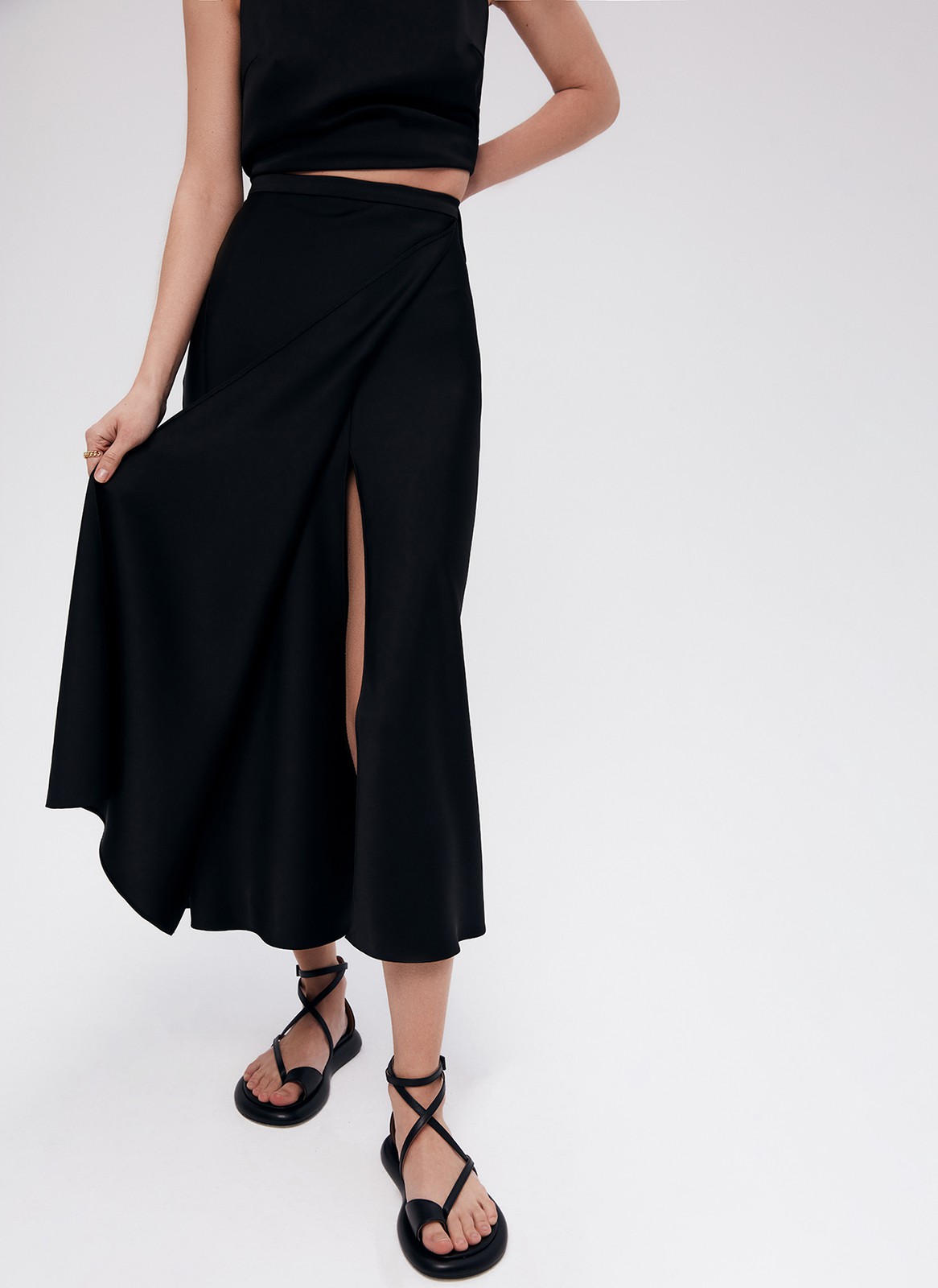 Юбка-миди с разрезом, цвет: Черный Allweneed
Юбка миди с косым кроем. Модель выполнена из легкой ткани атласного переплетения, которая благородно сияет на солнце. Высокий разрез спереди юбки аккуратно прикрывает декоративная деталь фартук. Разрез красиво раскрывается при шаге и дает свободу в движении. Носите, если хотите сделать образ необычным и смелым.Сочетайте с топами из вискозы, джемперами из кашемира и одеждой из костюмной ткани.
На модели размерXS