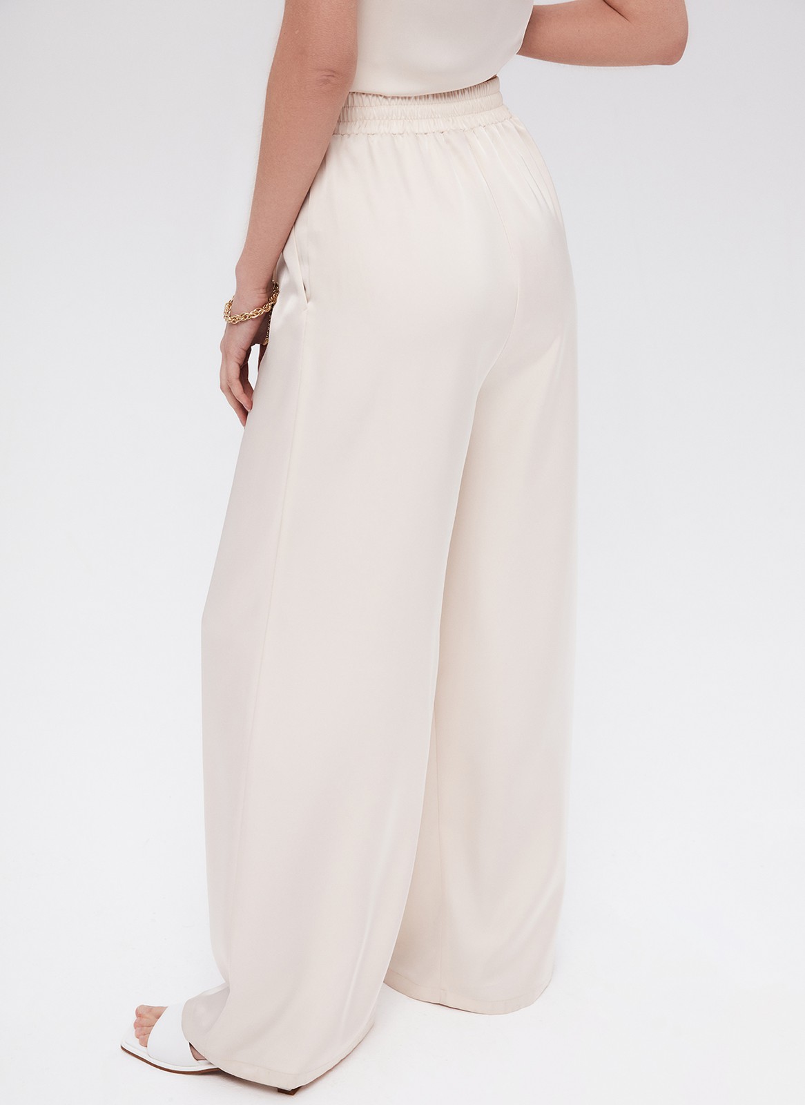 Брюки палаццо, цвет: бежевый Allweneed
Легкие брюки свободного кроя из ткани атласного переплетения. Ткань струится и переливается при ходьбе, но неприхотлива в уходе. Широкий пояс с резинкой, декоративный шнурок на поясе, глубокие складки на передней части брюк. Удобные карманы. Вы можете добавить по желанию изящные босоножки или удобные кеды, футболку oversize или топ с открытой спиной. Можно составить комплект с рубашкой и топом из нашей коллекции.
На модели размер XS