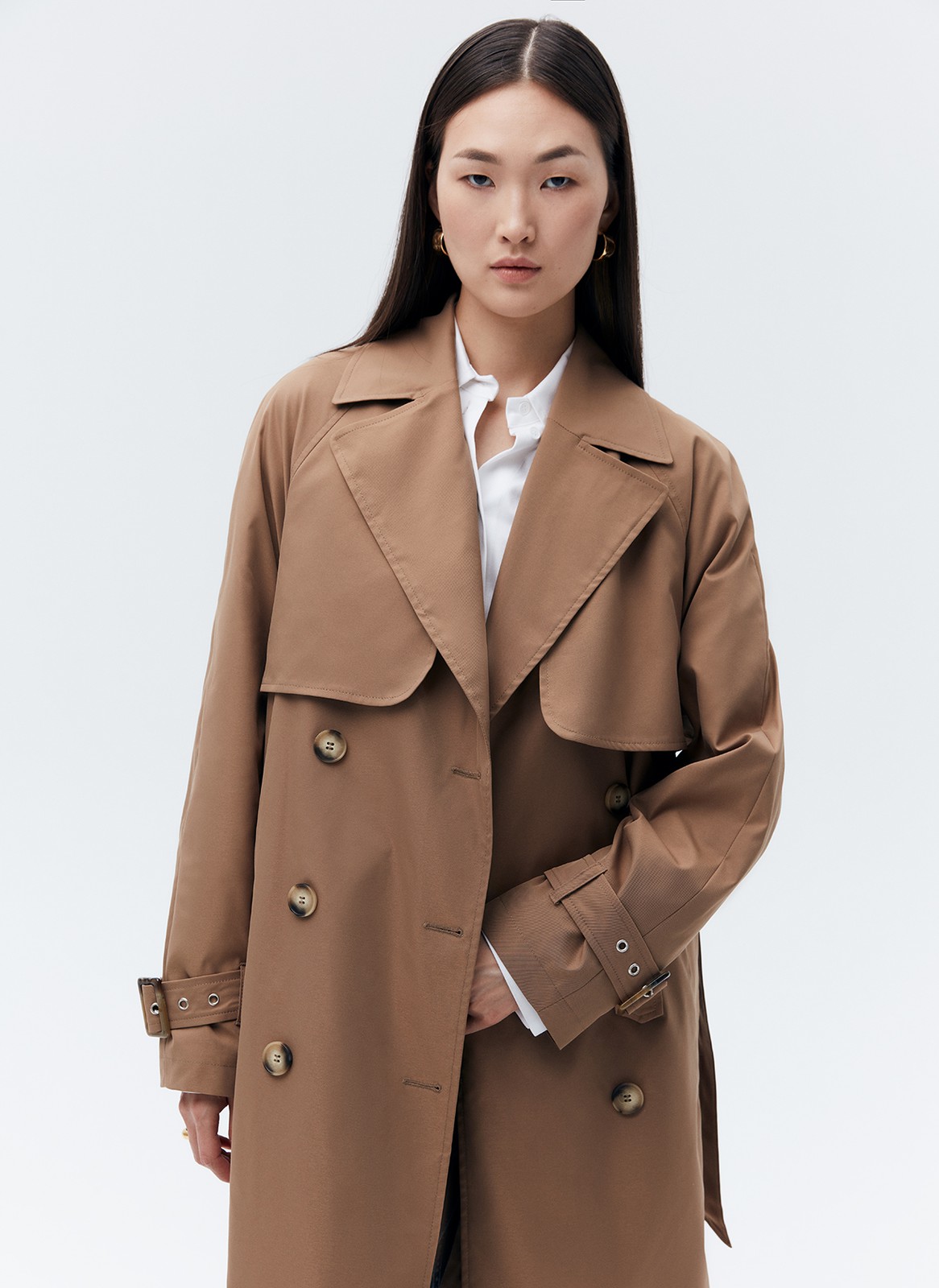 Тренч, цвет: кэмел Allweneed Плащдвубортного кроя с застежкой на крупные однотонные пуговицы. Отлетная кокетка, А-силуэт и длинный пояс на талии добавляют образу легкости, а цветовая гамма создает поистине весеннее настроение.