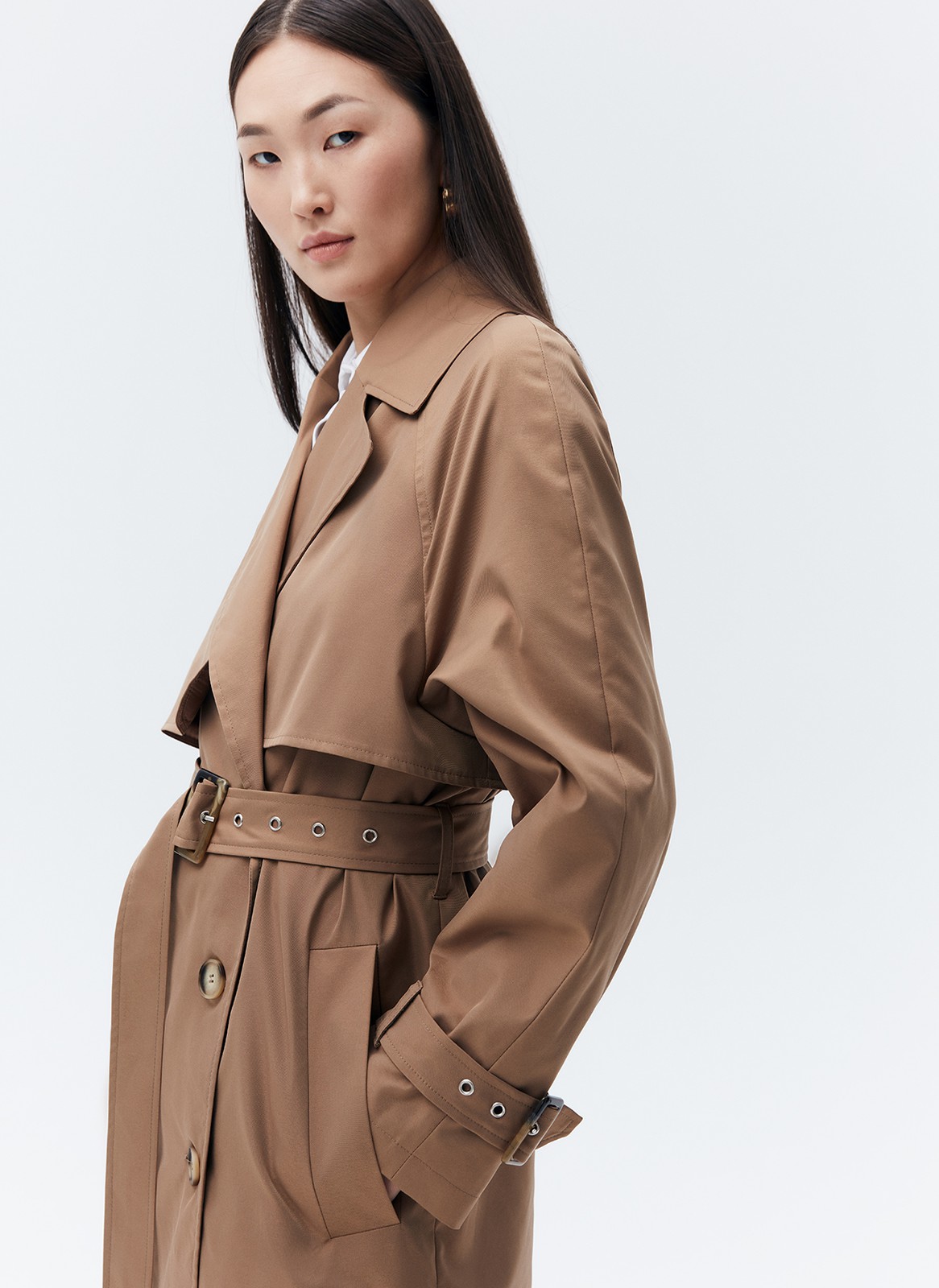 Тренч, цвет: кэмел Allweneed Плащдвубортного кроя с застежкой на крупные однотонные пуговицы. Отлетная кокетка, А-силуэт и длинный пояс на талии добавляют образу легкости, а цветовая гамма создает поистине весеннее настроение.