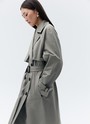 Тренч, цвет: серо-зеленый Allweneed Плащдвубортного кроя с застежкой на крупные однотонные пуговицы. Отлетная кокетка, А-силуэт и длинный пояс на талии добавляют образу легкости, а цветовая гамма создает поистине весеннее настроение.