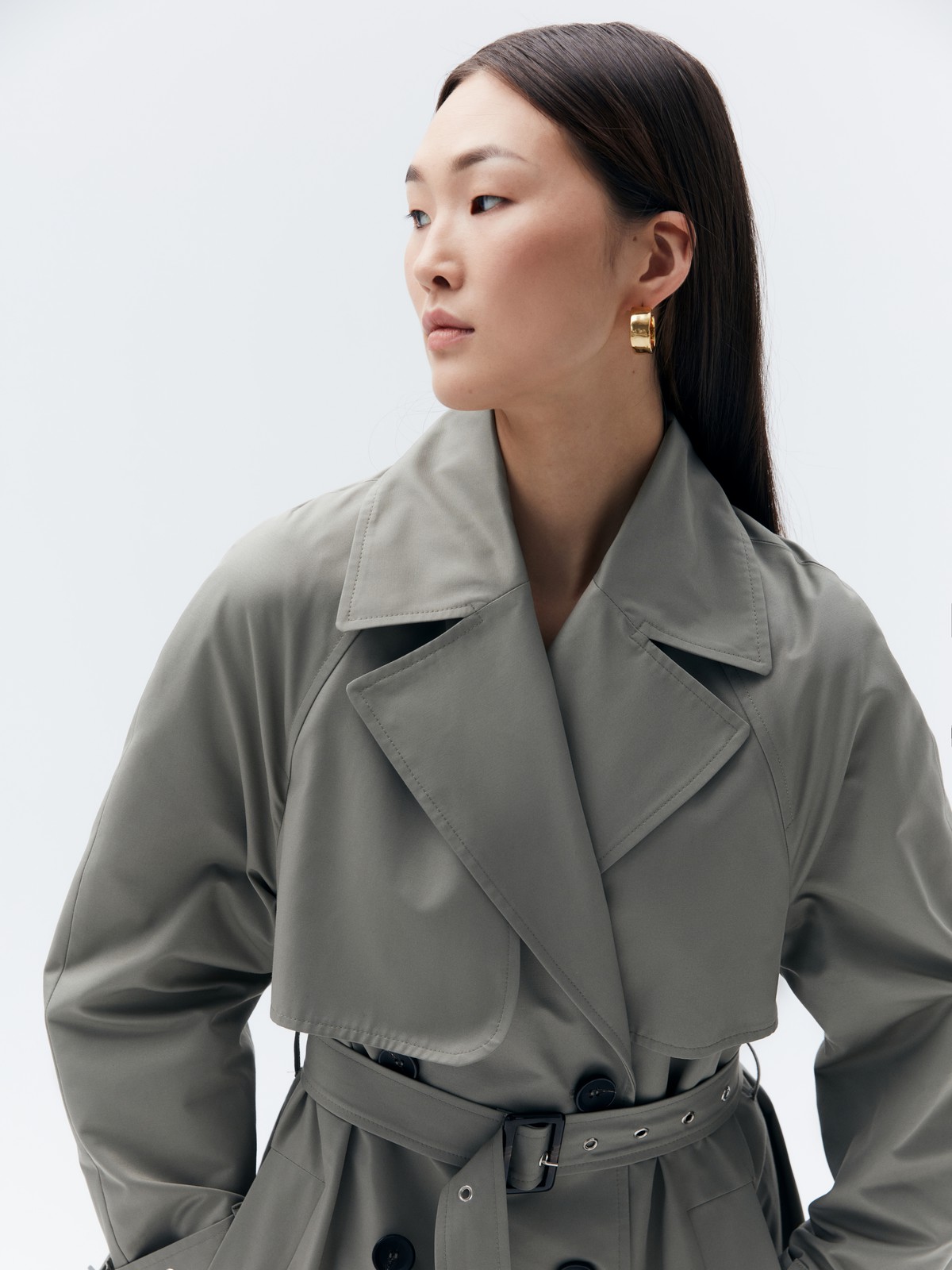 Тренч, цвет: серо-зеленый Allweneed Плащдвубортного кроя с застежкой на крупные однотонные пуговицы. Отлетная кокетка, А-силуэт и длинный пояс на талии добавляют образу легкости, а цветовая гамма создает поистине весеннее настроение.