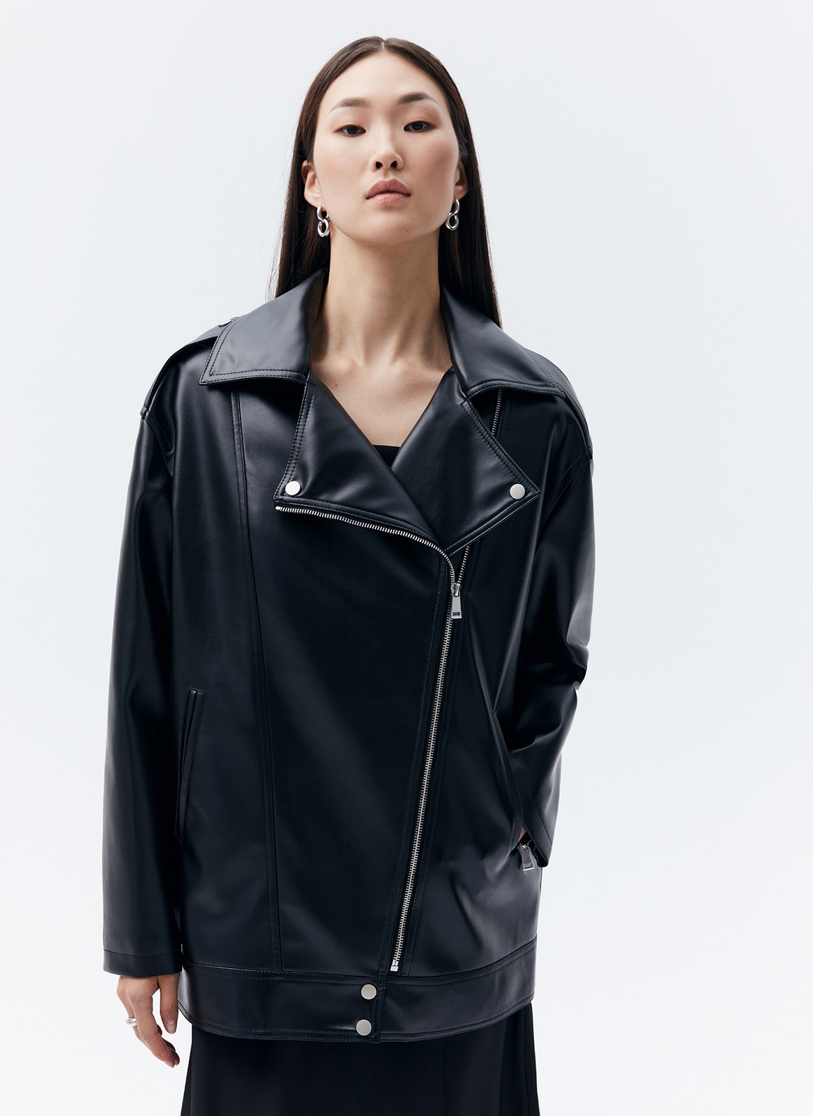 Куртка-косуха oversize из экокожи, цвет: черный №2 Allweneed Удлиненная куртка-косуха актуальна во все времена. Модель oversize выполнена из плотной и качественной экокожи. Куртка с широким воротником и двумя удобными карманами. Мы добавили металлическую фурнитуру и погоны. Классическая косая застежка и застежка-молния на рукавах. Рабочие кнопки на поясе и две декоративные кнопки на лацканах. Мы любим ее носить с джинсами и рубашкой. Три базовых цвета: чёрный, кэмел и молочный с черной фурнитурой.