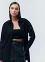 Рубашка oversize, цвет: Черный Allweneed Рубашка oversize из плотной ткани. Ткань пластичная и долго сохраняет первоначальный вид. Застежка на пуговицы и кокетка на спине для идеальной посадки. Благодаря перепаду длины и разрезам в боковых швах можно носить навыпуск с легинсами и велосипедками. Рубашку нам нравится надевать вместо легкого кардигана на сарафаны, топы и футболки. Сочетайте ее с изделиями из коллекции по настроению в любое время года.