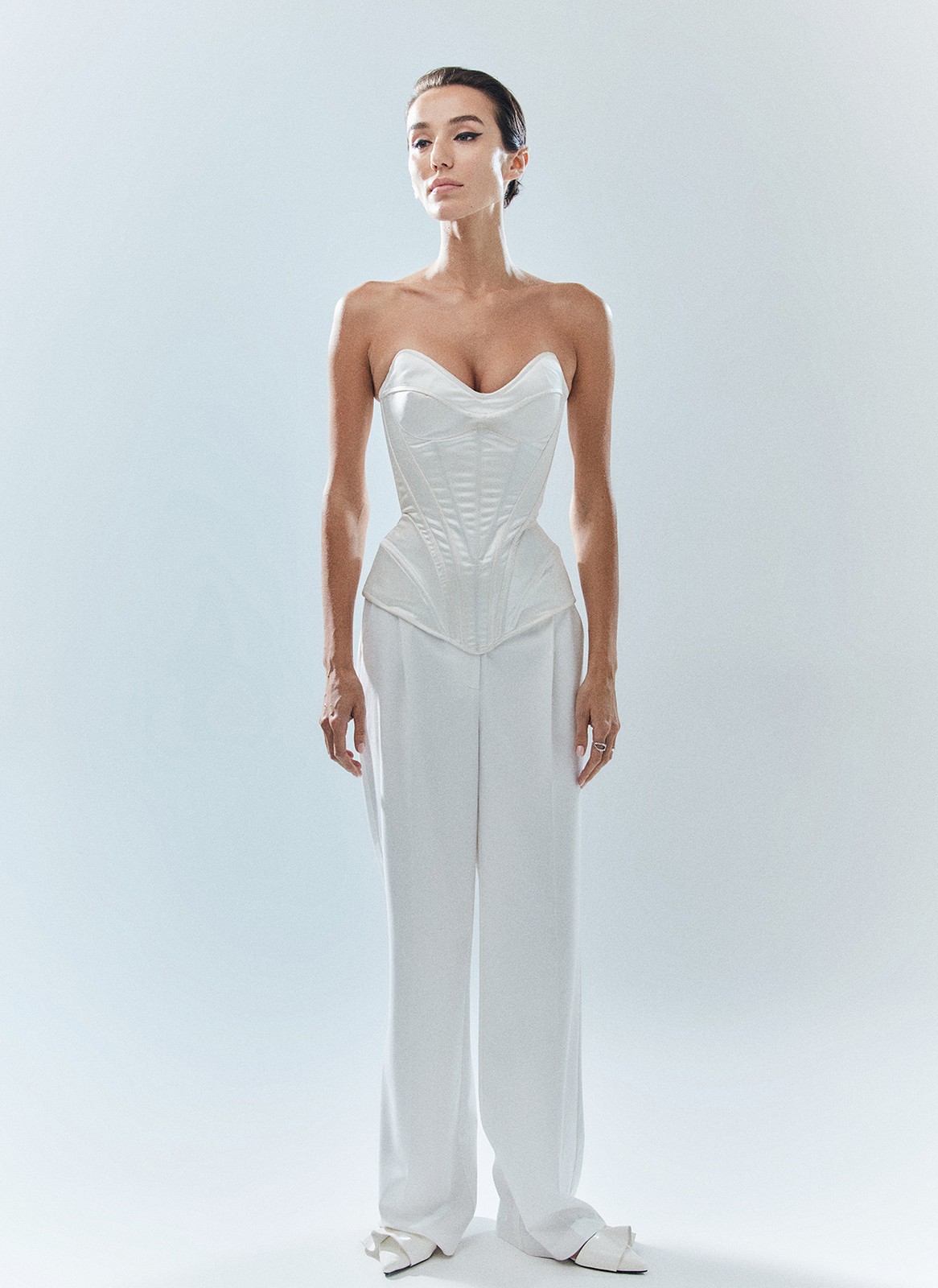 Брюки широкие полной длины, цвет: белый Allweneed Брюки на средней посадке полной длины. Скрытая застёжка на молнию. Модель свободного кроя делает силуэт визуально стройнее. Приятная к телу костюмная ткань хорошо держит форму и обеспечивает правильную посадку по фигуре. Мы рекомендуем сочетать брюки с жакетом из новогодней коллекции, дополняя комплект броскими украшениями в праздничную ночь и топом в рубчик в будничной жизни. Представлены в трёх цветах: сиреневый рассказывает о тихом утре 1 января, красный апельсин символизирует мандарины и гирлянды, а белый это чистый зимний снег.