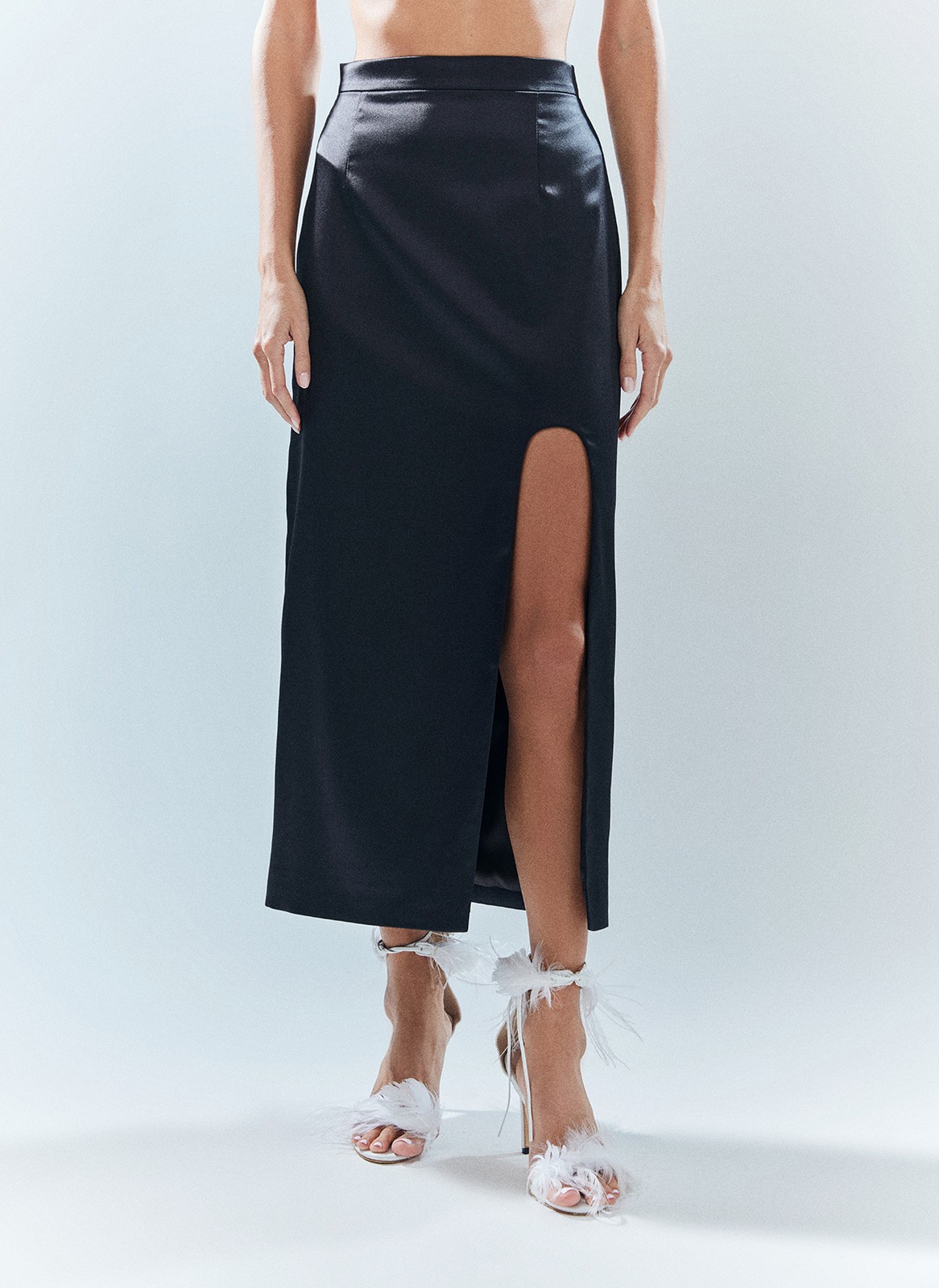 Юбка миди с разрезом, цвет: Черный Allweneed Атласная юбка длины миди с разрезом. Строгая и женственная одновременно, она стала частью наших размышлений о женском праздничном смокинге. Удобная посадка на талии, чтобы изделие смотрелось хорошо на разных фигурах. Модель подчёркивает красоту ваших ног благодаря смелому разрезу в ультрамодной форме арки. В новогоднюю ночь сочетайте с топом в бельевом стиле и оверсайз-жакетами, играя на контрастах кроя. После носите с базовыми лонгсливами, топом в рубчик и блузой с запахом.
