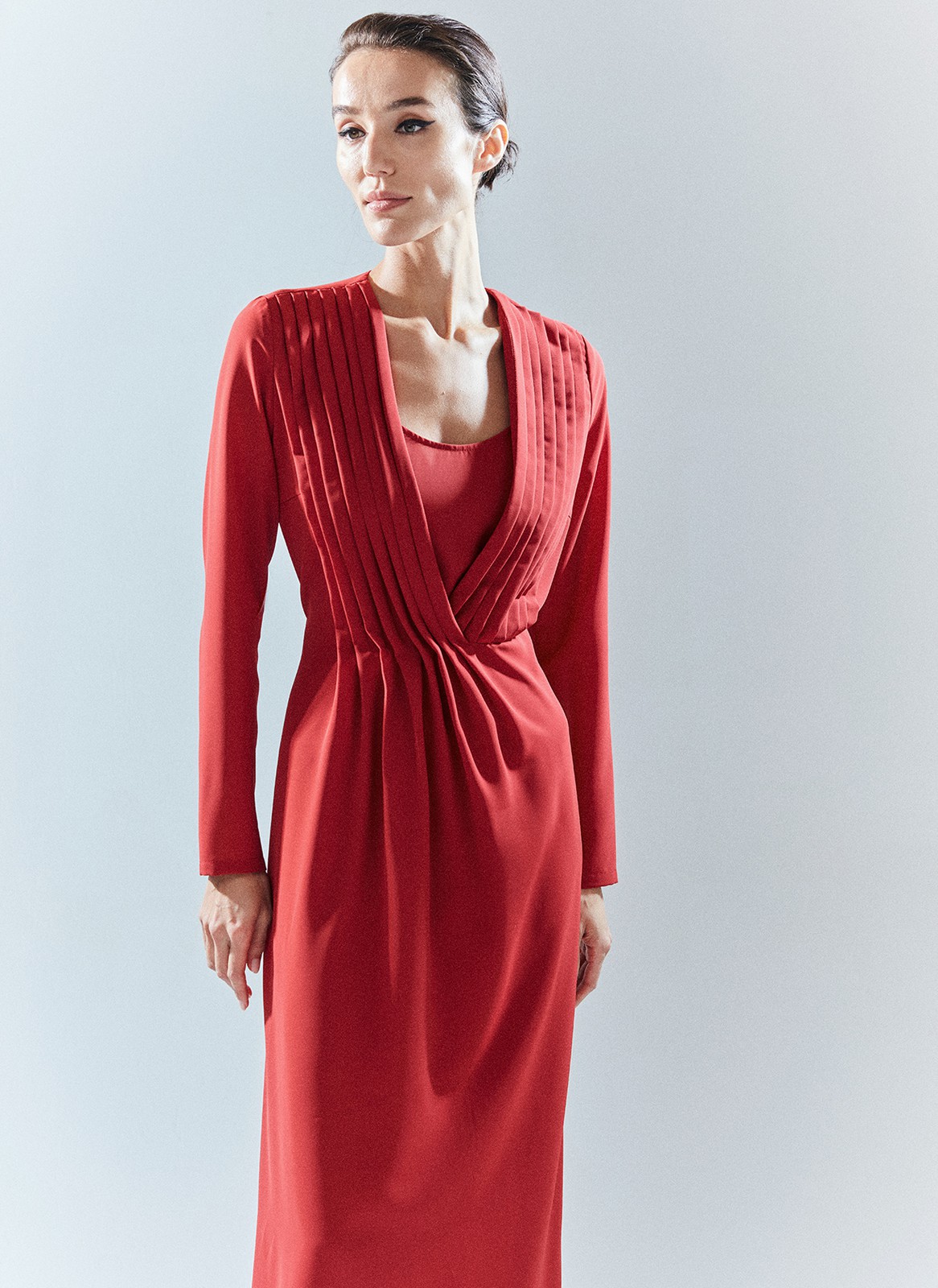 Платье длины миди с глубоким вырезом. Яркая модель новогодней коллекции. Драпировки в районе декольте добавляют платью торжественности. Акцент на талии формирует женственный силуэт. Платье создаёт иллюзию комплекта из юбки и блузы, дополняя концепцию парности нашей новогодней капсулы. Для создания модели мы использовали ткань с лёгким блеском в праздничном красном и нарядном чёрном цветах, чтобы вы сияли в новогоднюю ночь. Подберите к платью украшение на шею, так вы подчеркнёте красоту зоны ключиц.