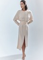 Платье длины миди с разрезом спереди. Свободный крой, деликатное сияние и струящийся материал. Акцентная деталь длинные манжеты с рядом декоративных пуговиц. На спине есть красивый V-образный вырез. Мы создали модель для праздничных моментов, но её легко добавить в гардероб на каждый день благодаря длинному рукаву и сдержанной зоне декольте. Носите для ощущения свободы в движениях или подчеркните талию широким поясом-кушаком ещё одним связующим звеном коллекции. Этот элемент костюма с восточными корнями в старину использовали и для хранения мелочей, и для утепления. Мы же оставили ему декоративное назначение.


