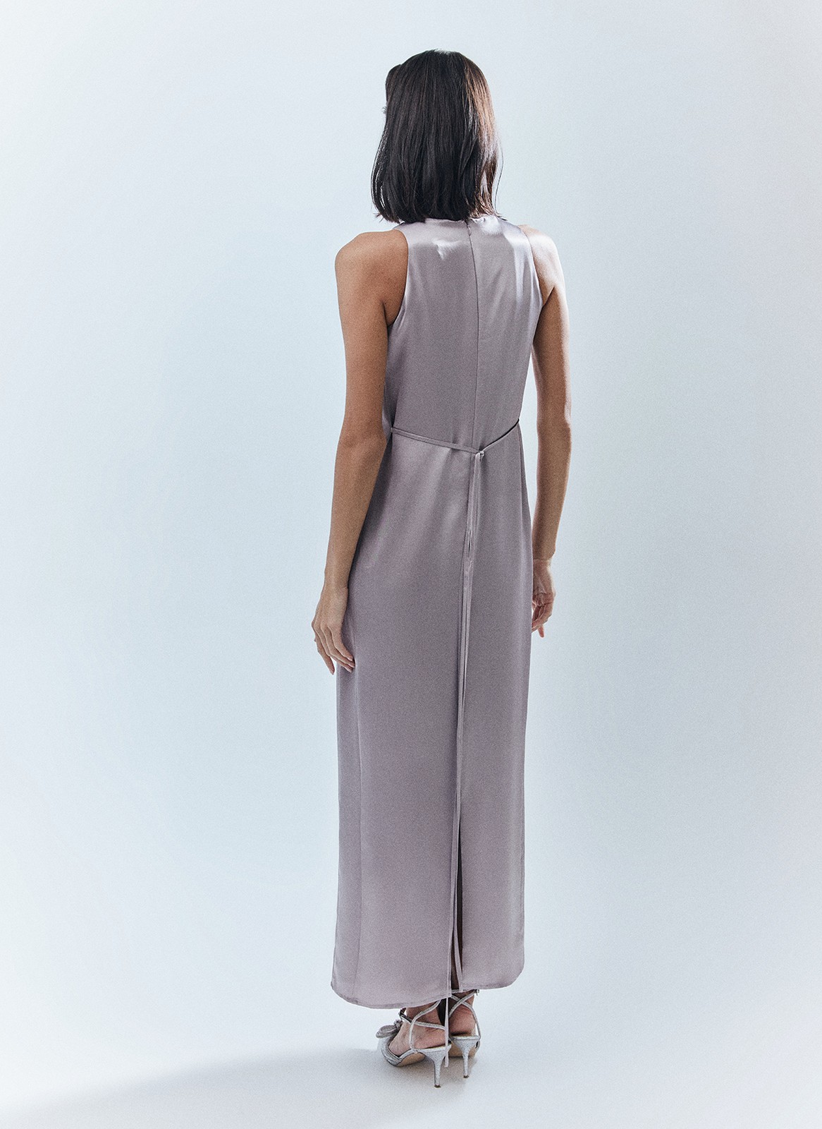 Платье длины макси с вырезом халтер. Легкая и летящая модель переливается и струится нежным водопадом по вашей коже. Специальная вытачка обеспечивает хорошую посадку по фигуре. Модель не слишком свободная, но и не слишком облегает. С помощью пояса-ленточки можно немного затянуть изделие. Наденьте платье на праздничный ужин с сияющими украшениями.

