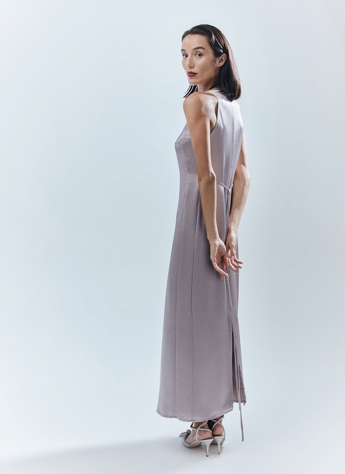 Платье длины макси с вырезом халтер. Легкая и летящая модель переливается и струится нежным водопадом по вашей коже. Специальная вытачка обеспечивает хорошую посадку по фигуре. Модель не слишком свободная, но и не слишком облегает. С помощью пояса-ленточки можно немного затянуть изделие. Наденьте платье на праздничный ужин с сияющими украшениями.

