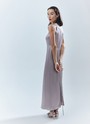 Платье длины макси с вырезом халтер. Легкая и летящая модель переливается и струится нежным водопадом по вашей коже. Специальная вытачка обеспечивает хорошую посадку по фигуре. Модель не слишком свободная, но и не слишком облегает. С помощью пояса-ленточки можно немного затянуть изделие. Наденьте платье на праздничный ужин с сияющими украшениями.


