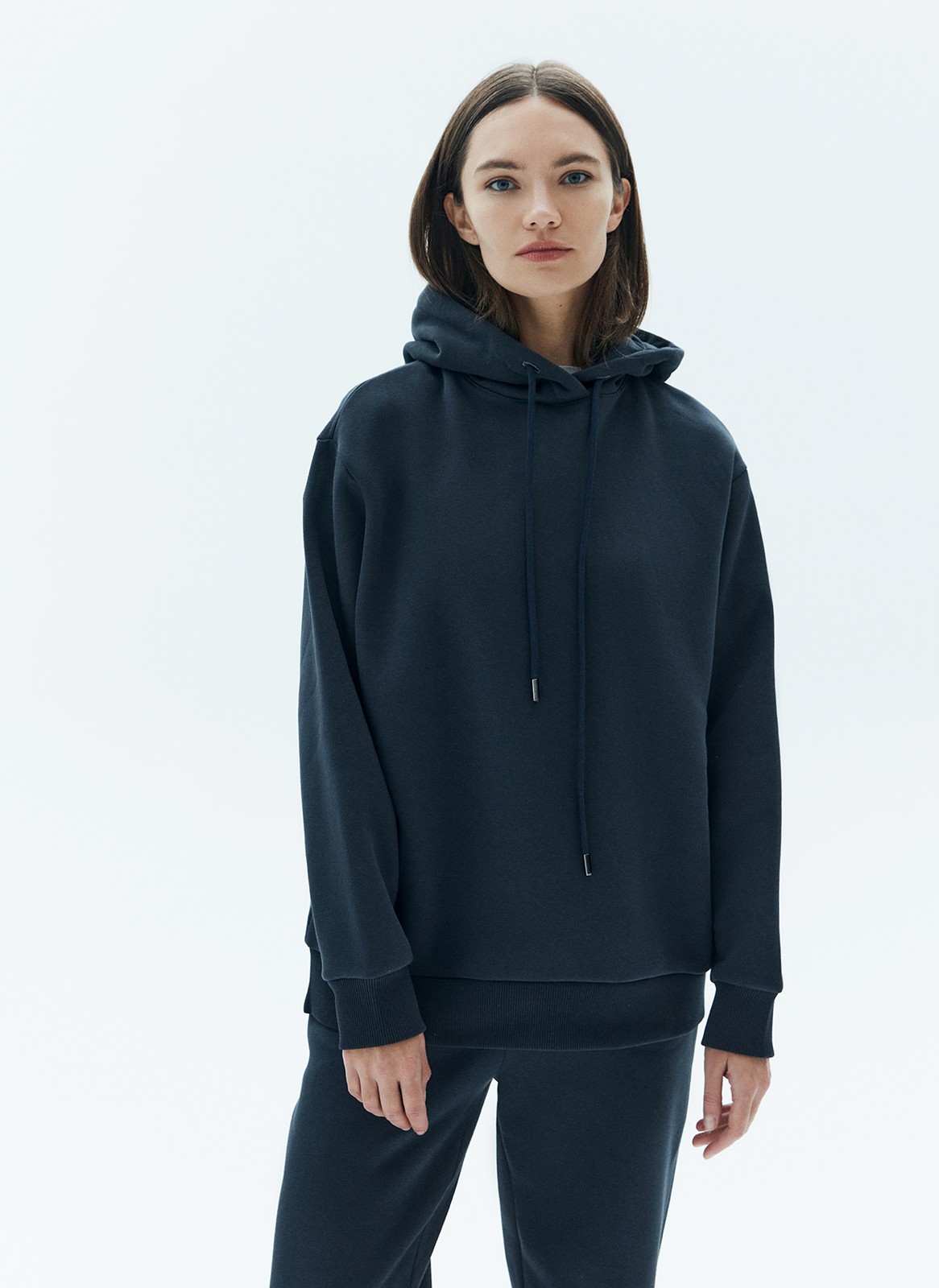 Свободное худи из мягкой ткани. Ткань очень приятно касается тела и позволяет вашей коже дышать. Удобный капюшон на кулиске. Прекрасный вариант, чтобы пробежаться до ближайшей пекарни выходным днем. Носите комплектом с трикотажными брюками или с любым низом из гардероба.