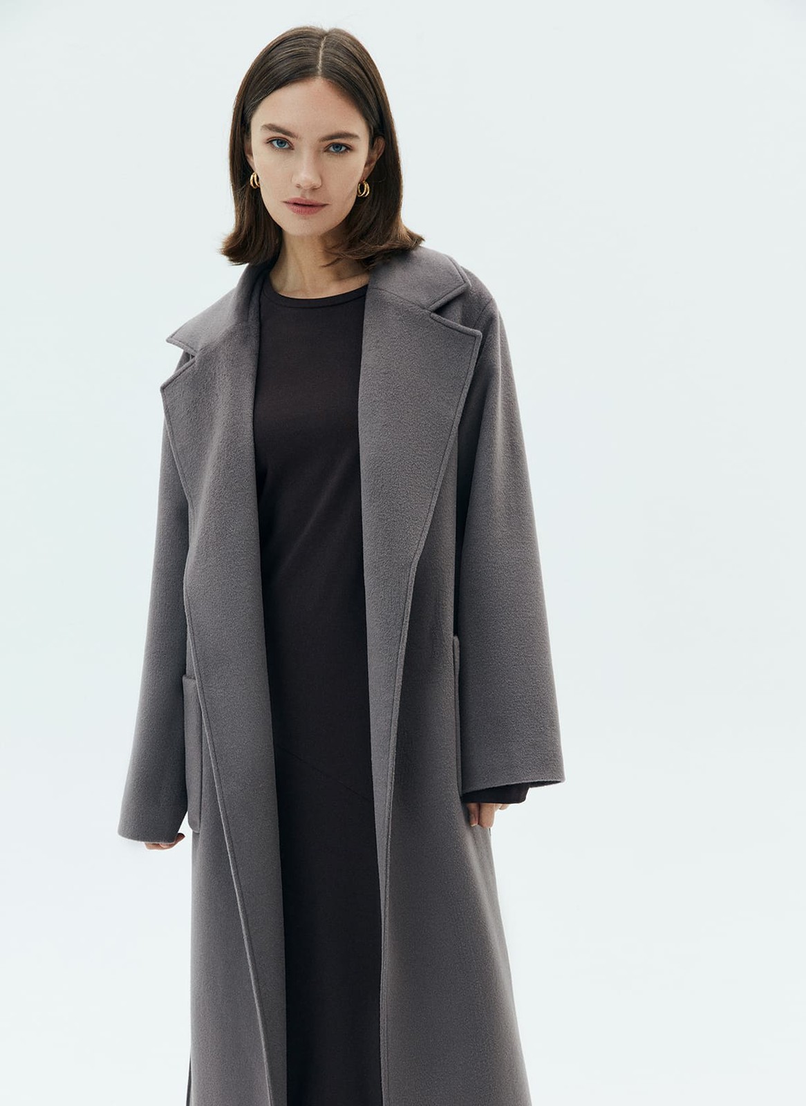 Пальто-халат с накладными карманами, цвет: темно-серый Allweneed
Пальто-халат в новом исполнении. Мы cделали более удлиненную модель, но сохранили все важные детали: отложной воротник, треугольные лацканы и пояс. Пальто выполнено из теплой шерсти с мягким отливом. Модель имеет два глубоких кармана для перчаток и других мелочей. Мы любим такой фасон за лаконичность и универсальность. Создавайте женственные образы или более расслабленные.