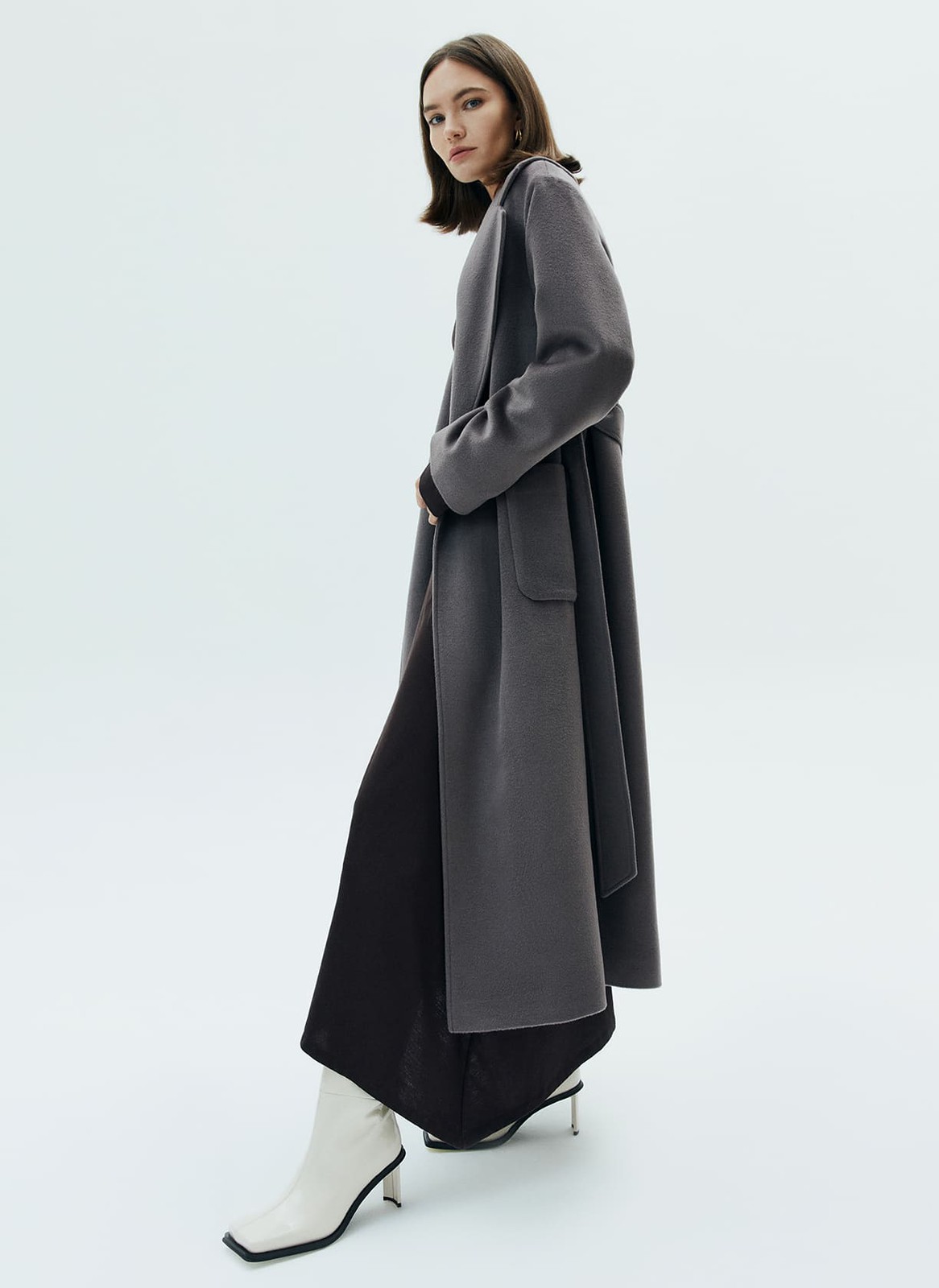 Пальто-халат с накладными карманами, цвет: темно-серый Allweneed
Пальто-халат в новом исполнении. Мы cделали более удлиненную модель, но сохранили все важные детали: отложной воротник, треугольные лацканы и пояс. Пальто выполнено из теплой шерсти с мягким отливом. Модель имеет два глубоких кармана для перчаток и других мелочей. Мы любим такой фасон за лаконичность и универсальность. Создавайте женственные образы или более расслабленные.