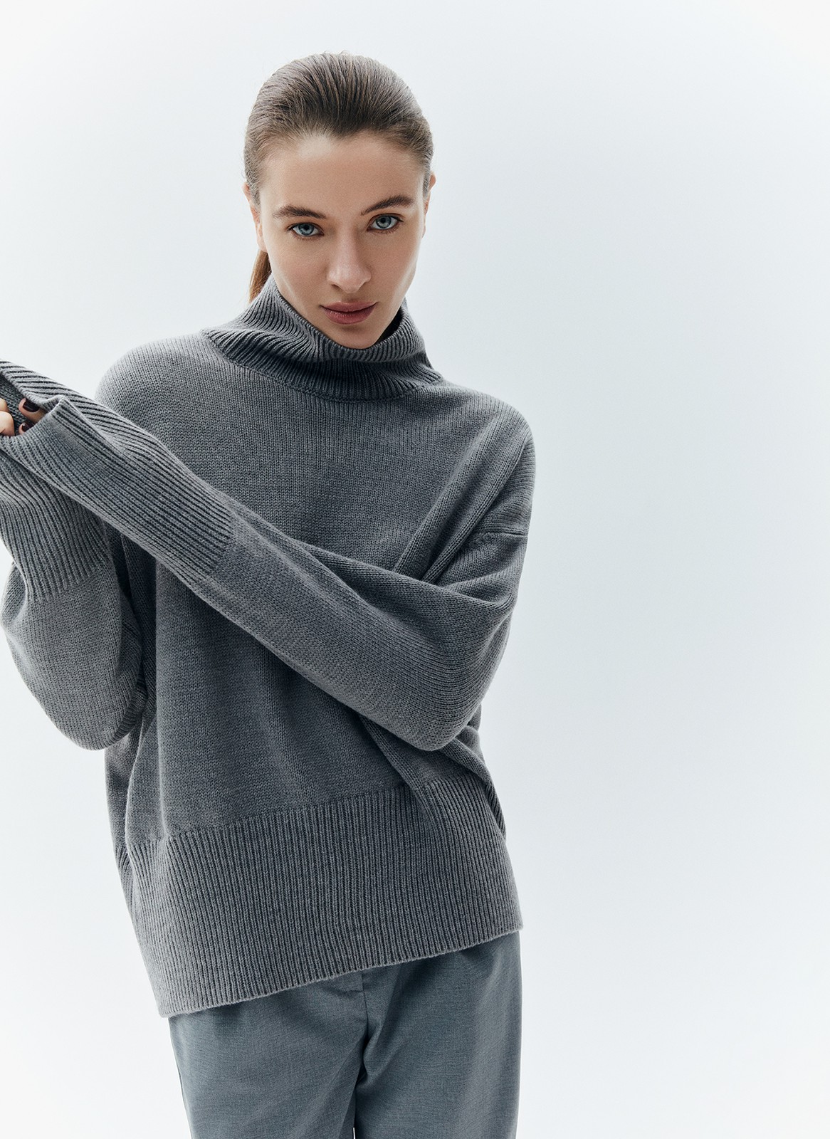 Шерстянойджемпер oversize. Высокая горловина оформлена ребристой окантовкой для уютного образа и защищает от сильного ветра, а спущенное плечо позволяет носить джемпер с футболками и водолазками для тепла. Модель легко садится под пальто с отложным воротником и заменяет шарф при плохой погоде. Джемпер станет отличным дополнением базового гардероба.