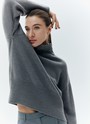 Шерстянойджемпер oversize. Высокая горловина оформлена ребристой окантовкой для уютного образа и защищает от сильного ветра, а спущенное плечо позволяет носить джемпер с футболками и водолазками для тепла. Модель легко садится под пальто с отложным воротником и заменяет шарф при плохой погоде. Джемпер станет отличным дополнением базового гардероба.