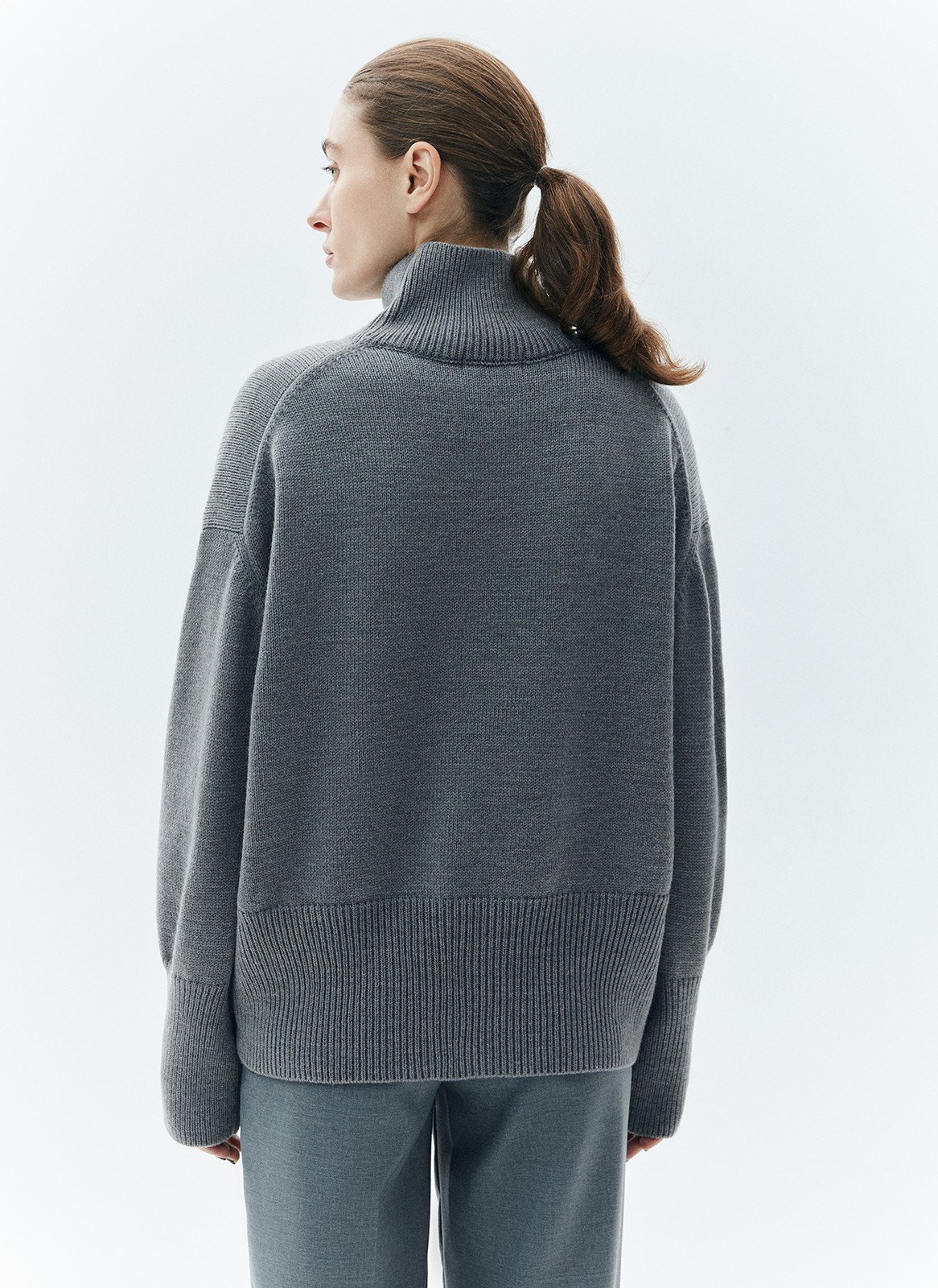 Шерстянойджемпер oversize. Высокая горловина оформлена ребристой окантовкой для уютного образа и защищает от сильного ветра, а спущенное плечо позволяет носить джемпер с футболками и водолазками для тепла. Модель легко садится под пальто с отложным воротником и заменяет шарф при плохой погоде. Джемпер станет отличным дополнением базового гардероба.