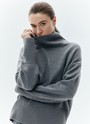 Шерстянойджемпер oversize. Высокая горловина оформлена ребристой окантовкой для уютного образа и защищает от сильного ветра, а спущенное плечо позволяет носить джемпер с футболками и водолазками для тепла. Модель легко садится под пальто с отложным воротником и заменяет шарф при плохой погоде. Джемпер станет отличным дополнением базового гардероба.