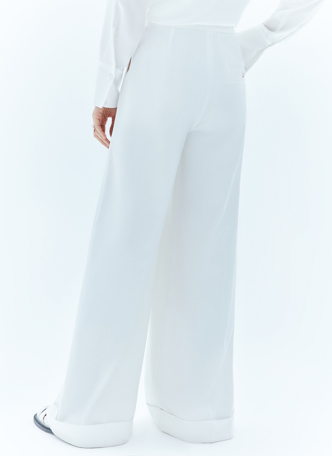 Широкие брюки полной длины с манжетами. Выполнены из мягкой, достаточно тонкой, но формоустойчивой костюмной ткани, благодаря которой будет комфортно весной. Удобная скрытая застёжка на крючки и посадка на уровне талии. Модель удлиняет силуэт. Советуем носить комплектом с жакетом из новой коллекции.
