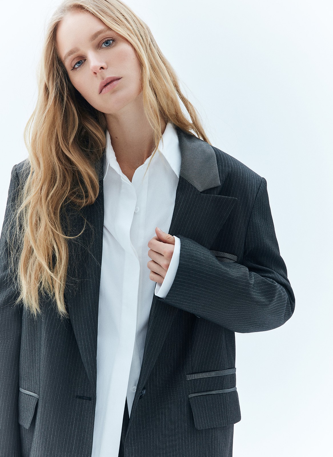 


Однобортный, удлинённый жакет свободного кроя. Благодаря фактуре материала имеет лёгкий деликатный блеск. Тонкая полоска тренд этой весны, идеально вписывающийся в морскую тему нашей коллекции и одновременно отсылающий нас к актуальному сейчас началу 2000-х. Лацканы выполнены из комбинации двух материалов (сияющего и более матового серого), предусмотрены двойные карманы с клапаном и контрастной отделкой, а также застёжка на одну пуговицу в тон. Имеет шлицу на спинке для комфорта, как и все наши жакеты.
Эффектный элемент модели маленький нагрудный кармашек с листочкой.

