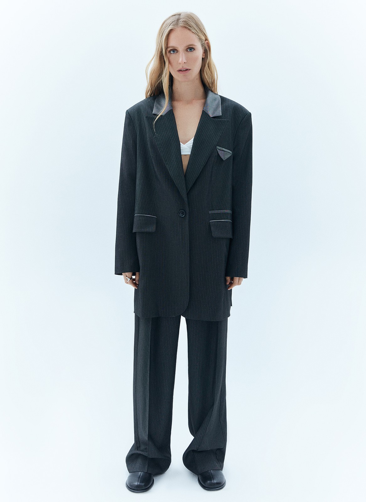 


Однобортный, удлинённый жакет свободного кроя. Благодаря фактуре материала имеет лёгкий деликатный блеск. Тонкая полоска тренд этой весны, идеально вписывающийся в морскую тему нашей коллекции и одновременно отсылающий нас к актуальному сейчас началу 2000-х. Лацканы выполнены из комбинации двух материалов (сияющего и более матового серого), предусмотрены двойные карманы с клапаном и контрастной отделкой, а также застёжка на одну пуговицу в тон. Имеет шлицу на спинке для комфорта, как и все наши жакеты.
Эффектный элемент модели маленький нагрудный кармашек с листочкой.
