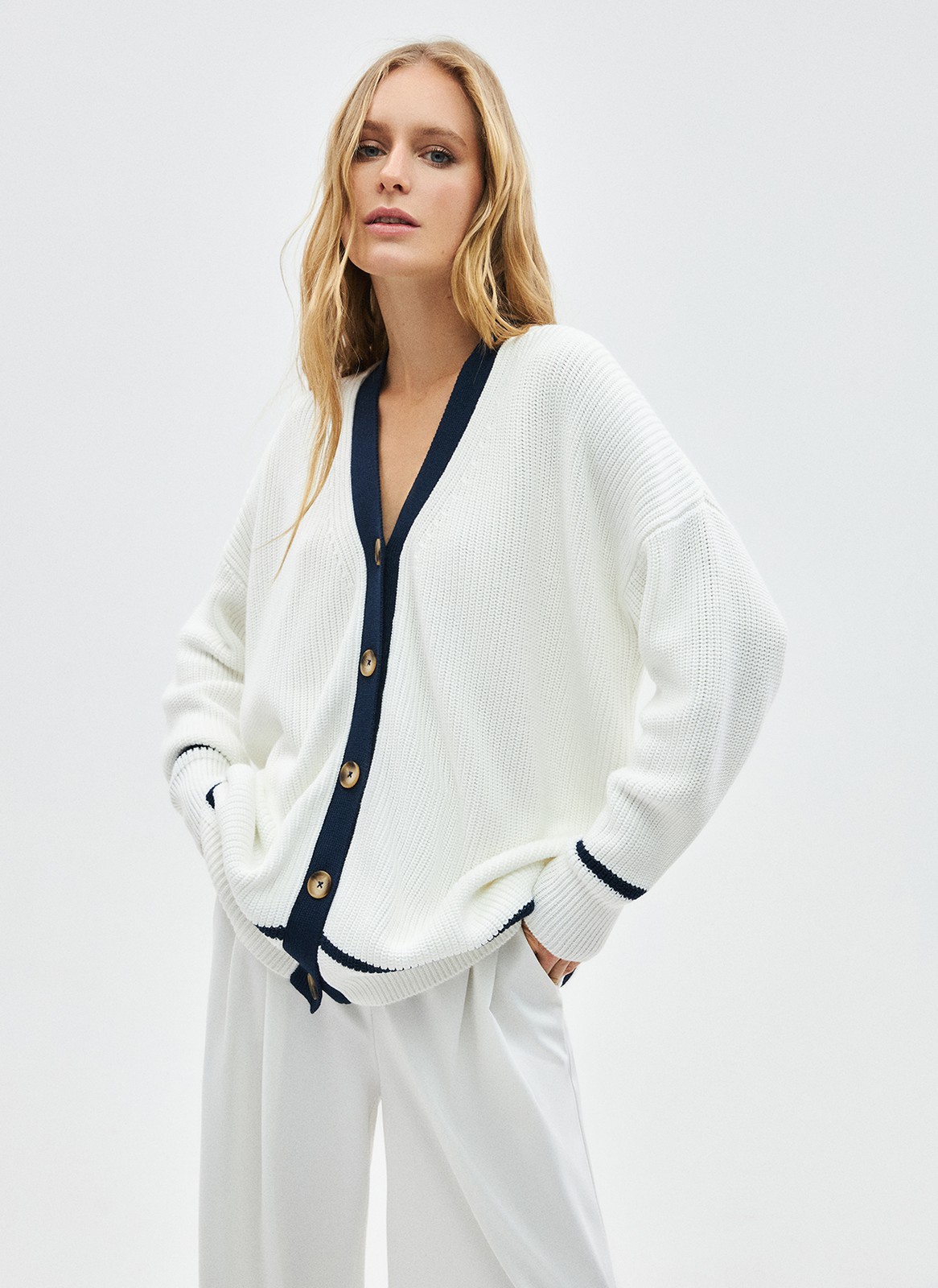 Кардиган фактурный, цвет: Молочно-синий Allweneed Объёмный кардиган крупной вязки. Дарит уют, сохраняя при этом статусность образа благодаря сочетанию оттенков и классическому фасону изделия словно из журналов и фильмов прошлого. V-образный вырез подчёркивает красоту зоны декольте. Длинные рукава с эластичными манжетами и застёжка на крупные роговые пуговицы. По низу изделия пущена контрастная полоска в тон окантовке, что отсылает нас к морской тематике. Прекрасный выбор для вечерних посиделок на веранде.