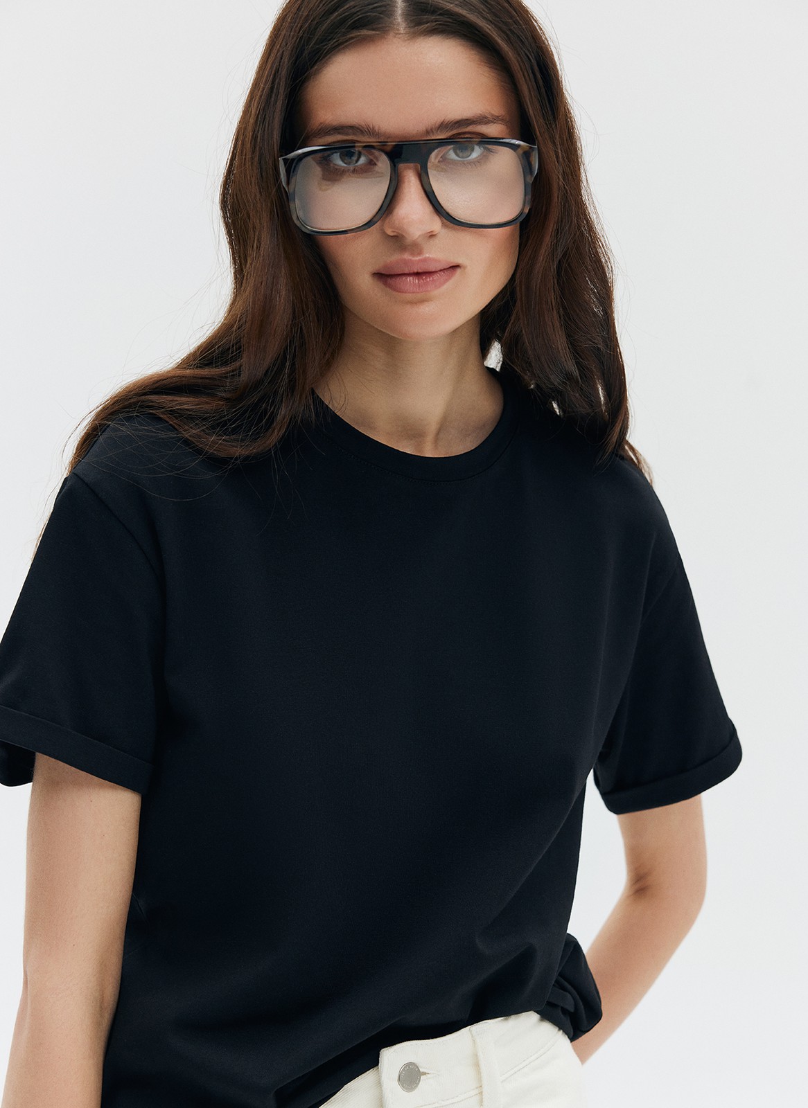 Футболка из эластичного, мягкого хлопка. Базовая модель свободного кроя со спущенным плечом. Благодаря материалу в футболке комфортно целый день идеально для жаркого времени года. Носите с джинсами, юбками и брюками.