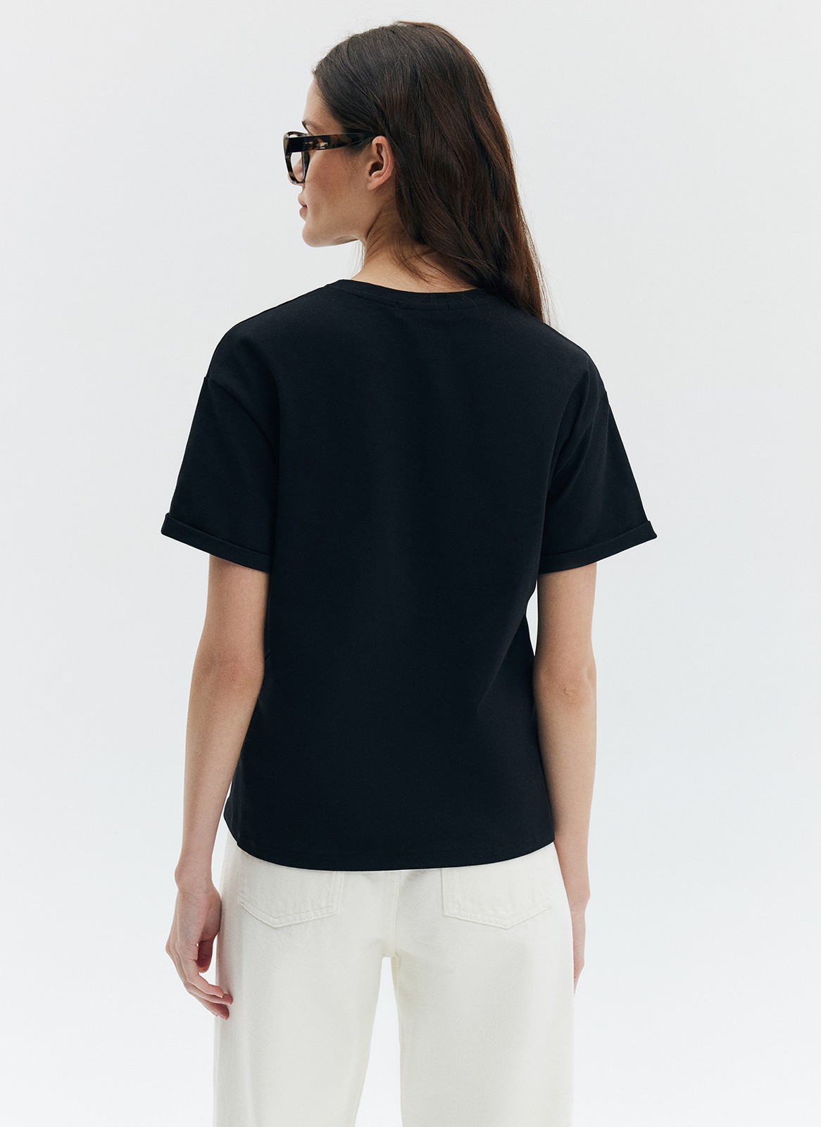Футболка из эластичного, мягкого хлопка. Базовая модель свободного кроя со спущенным плечом. Благодаря материалу в футболке комфортно целый день идеально для жаркого времени года. Носите с джинсами, юбками и брюками.