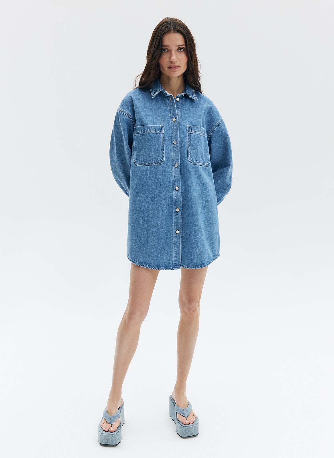 Удлиненная рубашка из денима останется классикой на долгие годы. Планка с пуговицами, отложной воротник и спущенное плечо. Носите как платье или как рубашку. Модель выполнена из премиального 100% хлопкового денима с брендированной фурнитурой.