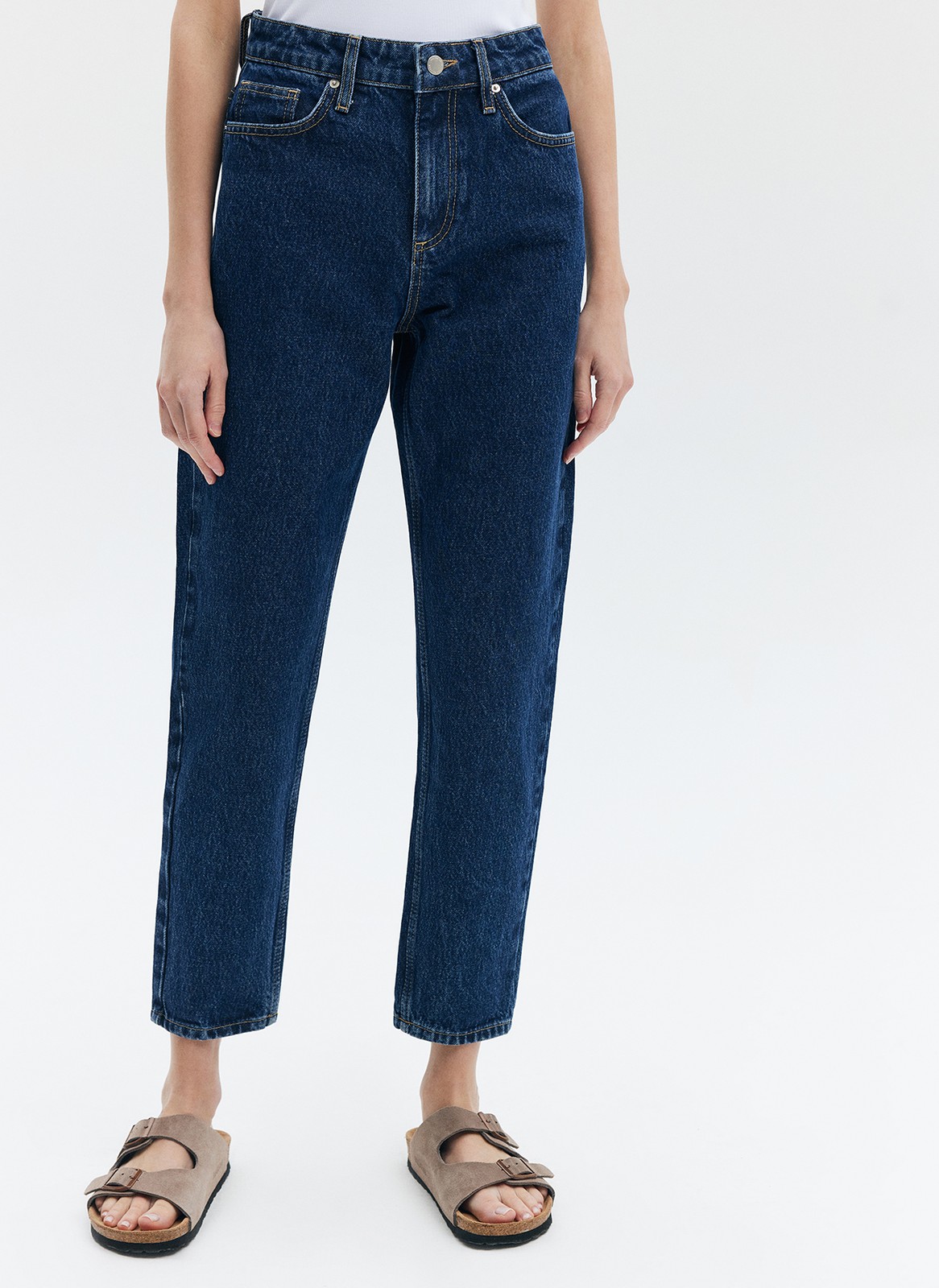 Джинсы Mom fit формируют красивую линию бедра. Слегка свободные, зауженные книзу. Укороченная модель подчеркивает красоту щиколоток. Выполнены из премиального 100% хлопкового денима с авторской варкой и брендированной фурнитурой.