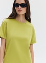Футболка из эластичного, мягкого хлопка. Базовая модель свободного кроя со спущенным плечом. Благодаря материалу в футболке комфортно целый день идеально для жаркого времени года. Носите с джинсами, юбками и брюками.