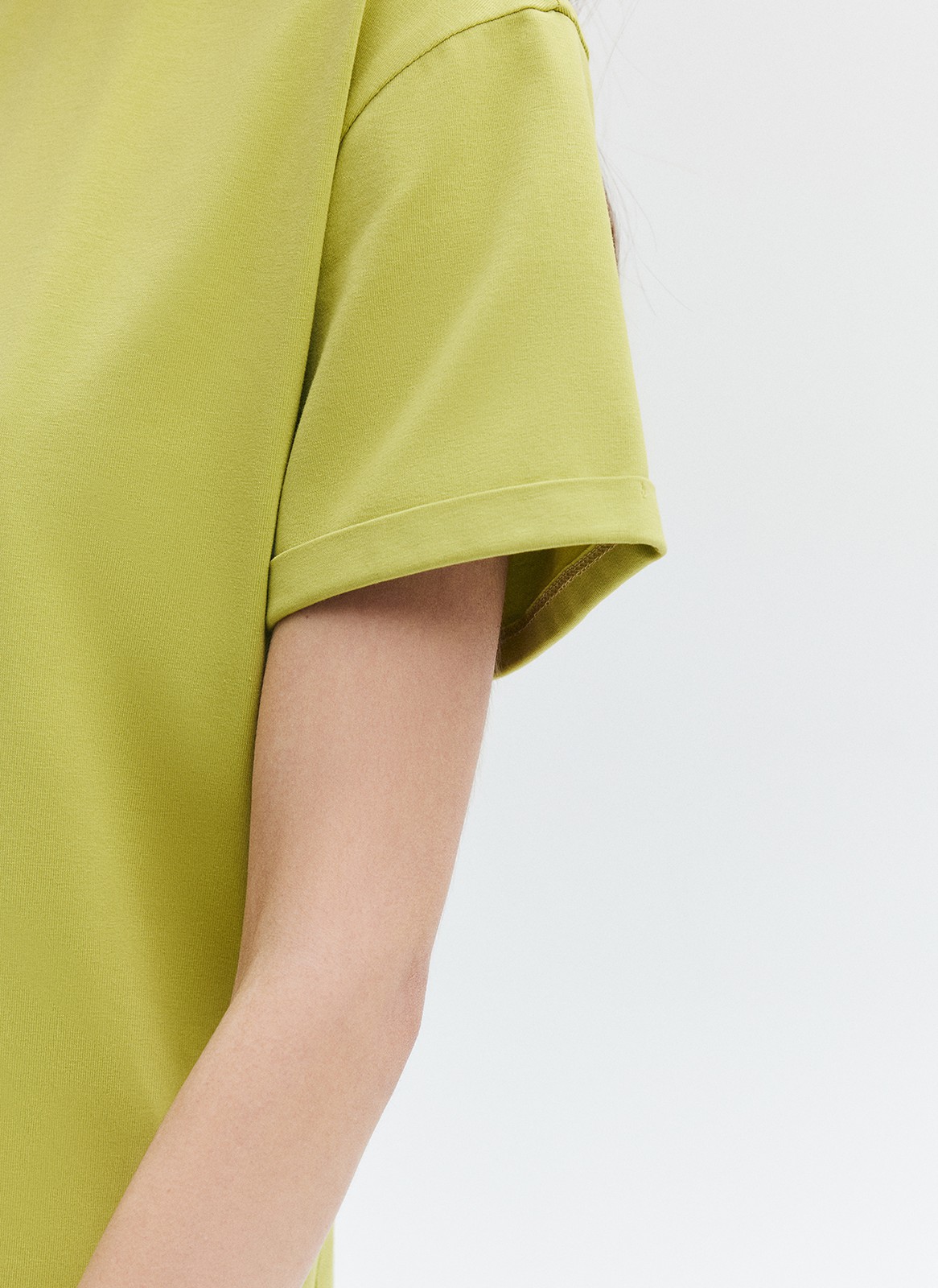 Футболка из эластичного, мягкого хлопка. Базовая модель свободного кроя со спущенным плечом. Благодаря материалу в футболке комфортно целый день идеально для жаркого времени года. Носите с джинсами, юбками и брюками.