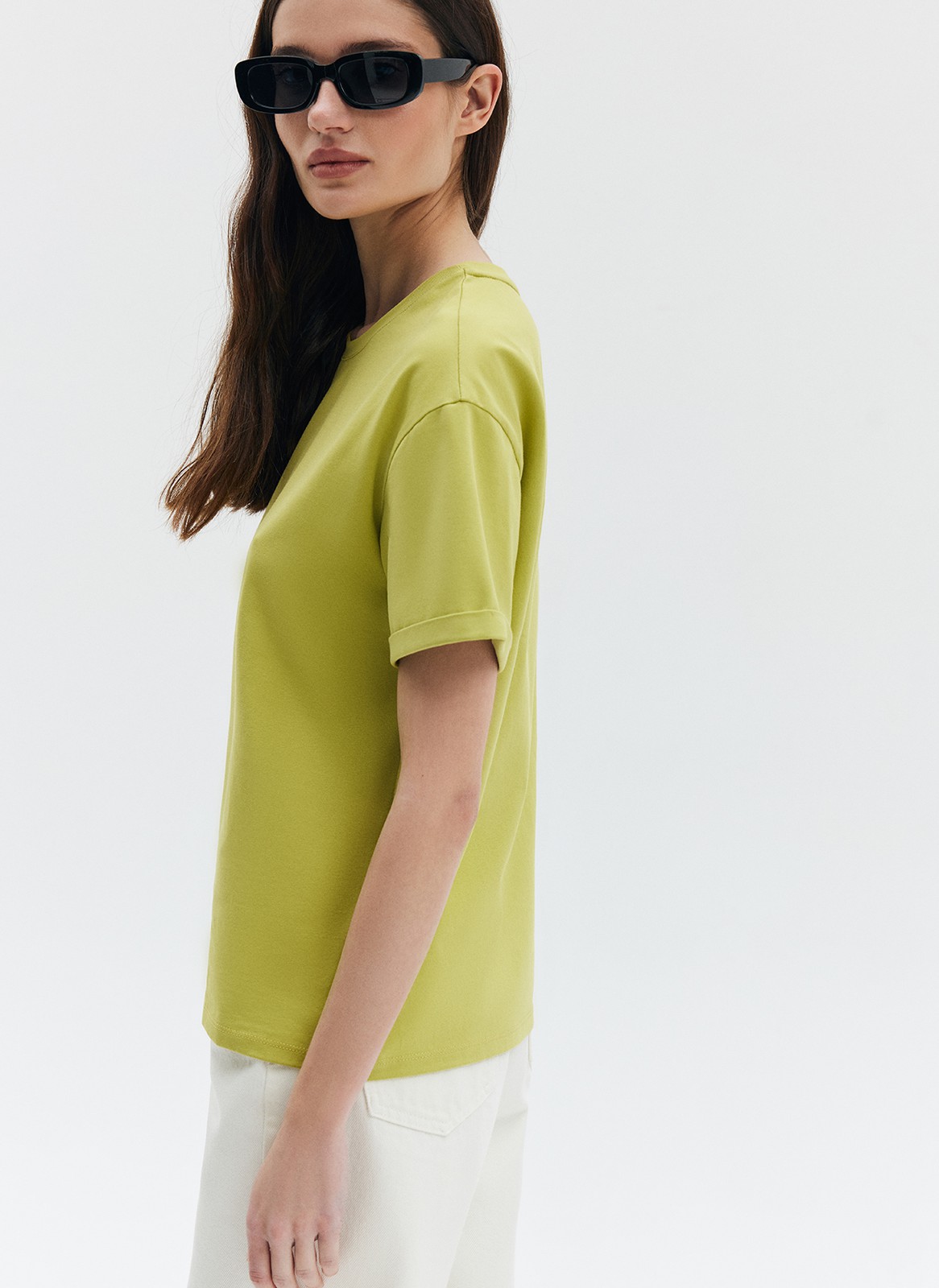 Футболка из эластичного, мягкого хлопка. Базовая модель свободного кроя со спущенным плечом. Благодаря материалу в футболке комфортно целый день идеально для жаркого времени года. Носите с джинсами, юбками и брюками.