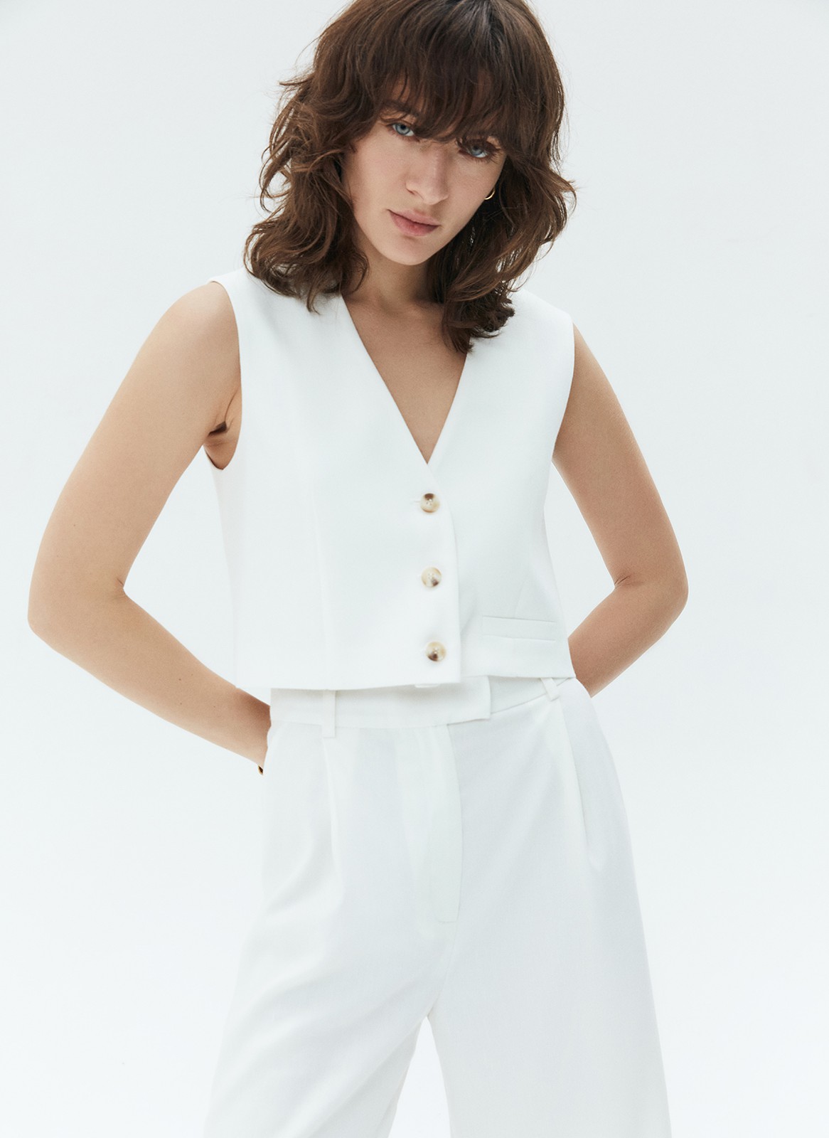 Жилет из костюмной ткани с добавлением льна. Планка на пуговицах в тон. V-образный вырез подчёркивает красоту шеи. Такой жилет станет прекрасной альтернативой классическому жакету летом. Сочетайте с шортами на высокой талии.