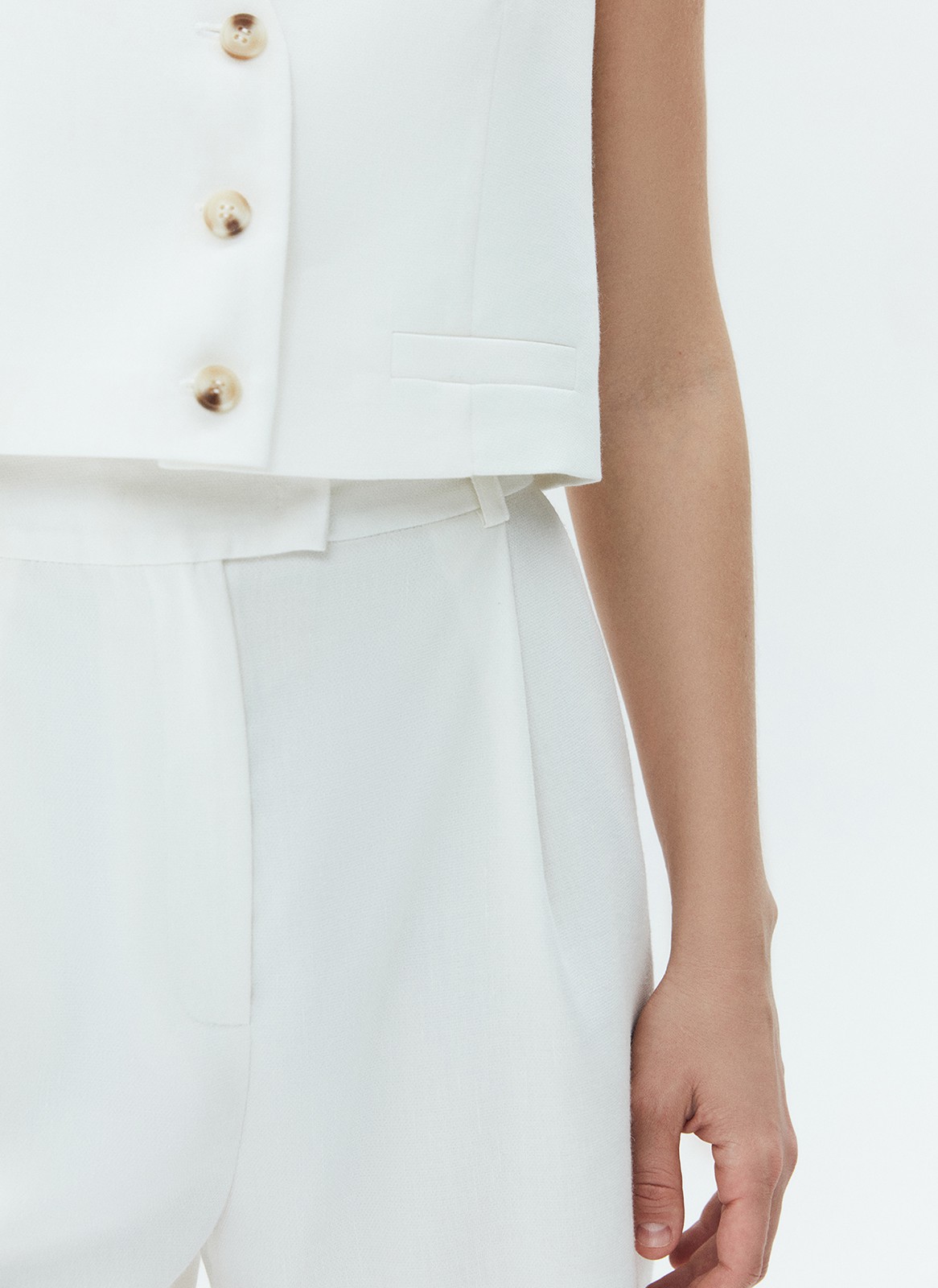 Жилет из костюмной ткани с добавлением льна. Планка на пуговицах в тон. V-образный вырез подчёркивает красоту шеи. Такой жилет станет прекрасной альтернативой классическому жакету летом. Сочетайте с шортами на высокой талии.