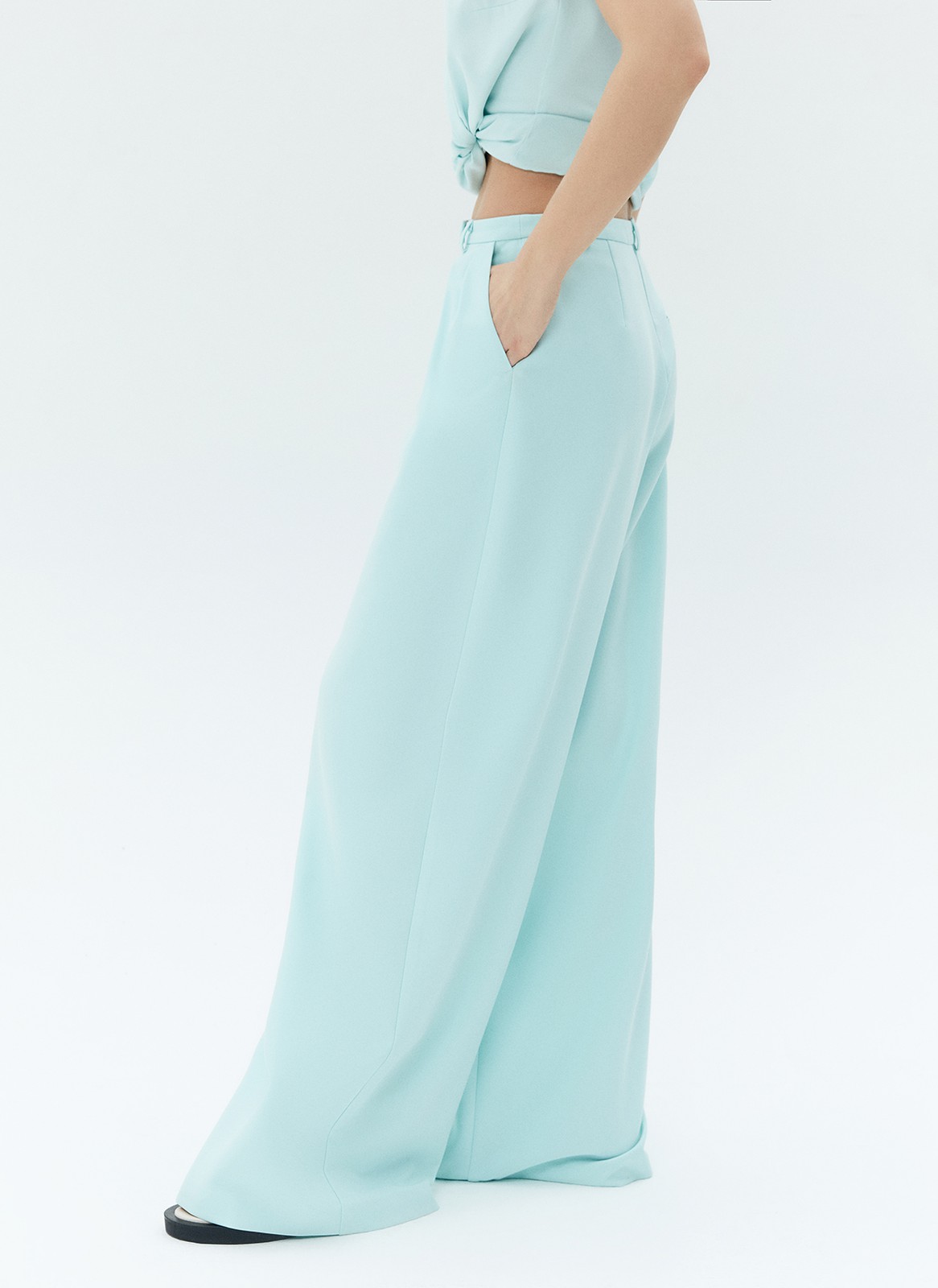 Брюки широкие полной длины. Посадка чуть ниже линии талии. Два глубоких боковых кармана. Мы кропотливо работали с костюмной тканью, чтобы она красиво струилась при ходьбе. Сочетайте со свободным жакетом из новой капсулы.