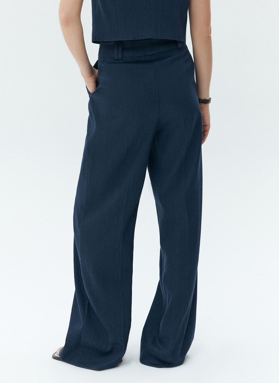 Широкие брюки полной длины из костюмной ткани с добавлением льна. Ткань с лёгким сатиновым блеском, которая красиво струится при движении. Посадка на талии и скрытая застёжка на молнию и крючок. Такой фасон отлично вытягивает силуэт и делает ноги визуально стройнее. Рекомендуем сочетать с жакетом в тон.