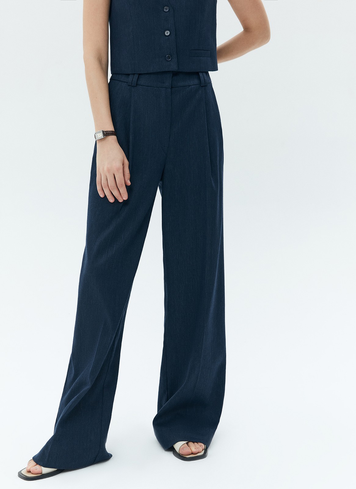 Широкие брюки полной длины из костюмной ткани с добавлением льна. Ткань с лёгким сатиновым блеском, которая красиво струится при движении. Посадка на талии и скрытая застёжка на молнию и крючок. Такой фасон отлично вытягивает силуэт и делает ноги визуально стройнее. Рекомендуем сочетать с жакетом в тон.