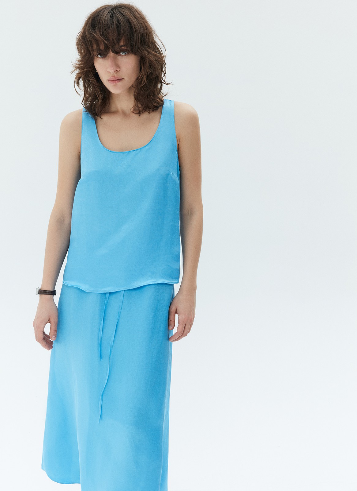 Топ на широких бретелях, цвет: голубой Allweneed Базовый топ на широких бретелях. Тонкая ткань с лёгким сатиновым свечением. Округлый вырез с окантовкой. Модель прямогосилуэта, поэтому она подойдёт девушкам с разной фигурой. Мы сочетаем это изделие как со строгими вещами из офисного гардероба, так и с любимыми джинсовыми шортами и летящими юбкам