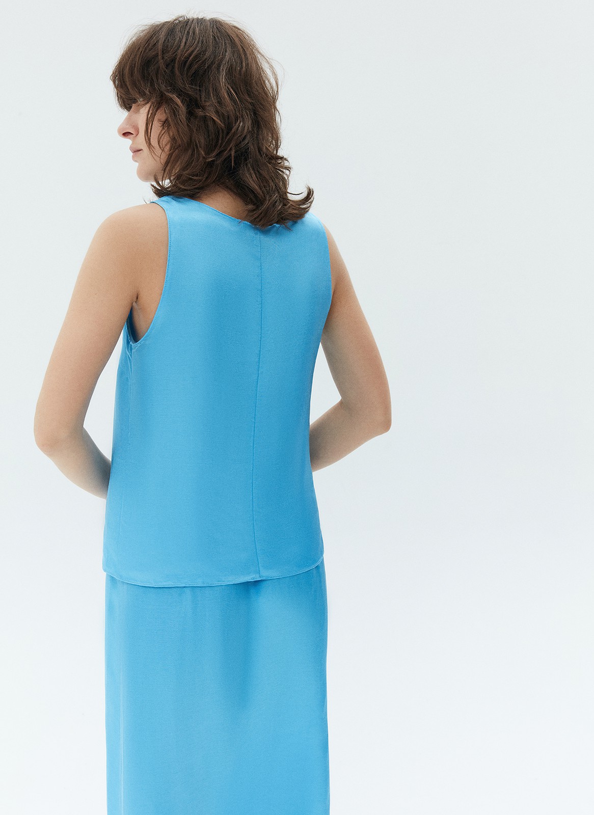 Топ на широких бретелях, цвет: голубой Allweneed Базовый топ на широких бретелях. Тонкая ткань с лёгким сатиновым свечением. Округлый вырез с окантовкой. Модель прямогосилуэта, поэтому она подойдёт девушкам с разной фигурой. Мы сочетаем это изделие как со строгими вещами из офисного гардероба, так и с любимыми джинсовыми шортами и летящими юбкам