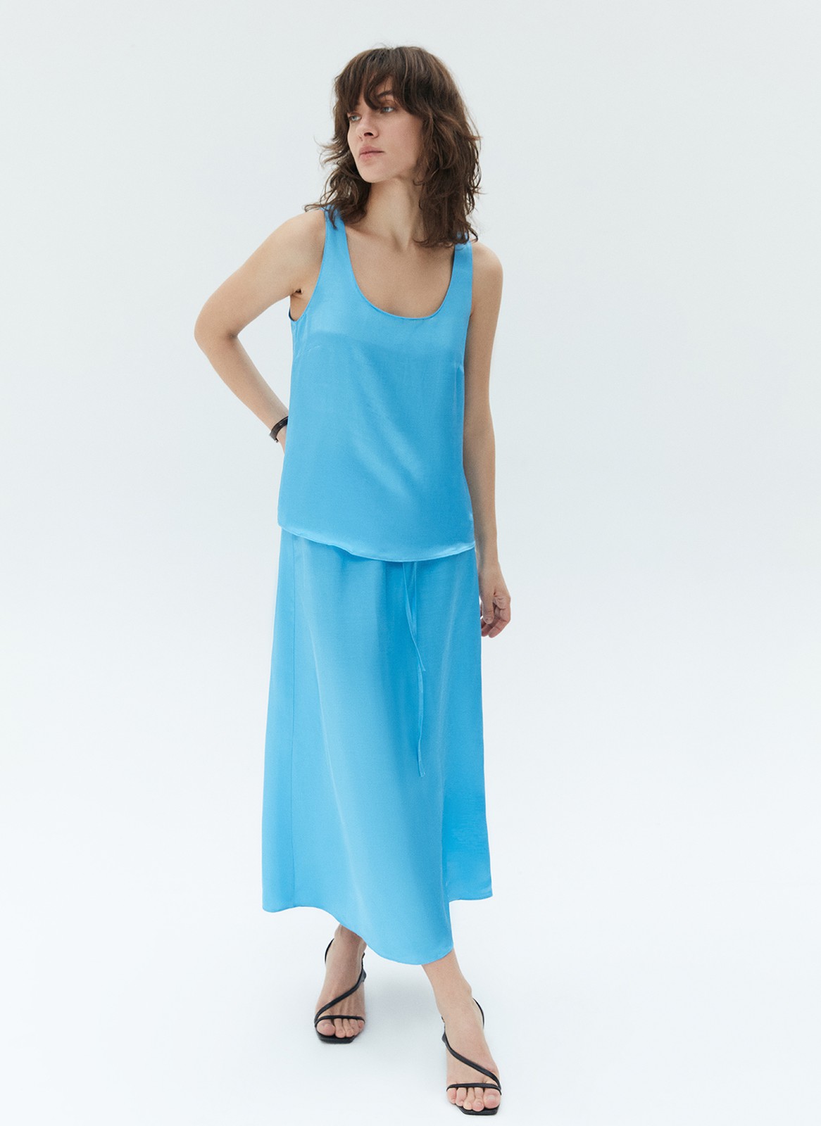 Топ на широких бретелях, цвет: голубой Allweneed Базовый топ на широких бретелях. Тонкая ткань с лёгким сатиновым свечением. Округлый вырез с окантовкой. Модель прямогосилуэта, поэтому она подойдёт девушкам с разной фигурой. Мы сочетаем это изделие как со строгими вещами из офисного гардероба, так и с любимыми джинсовыми шортами и летящими юбкам