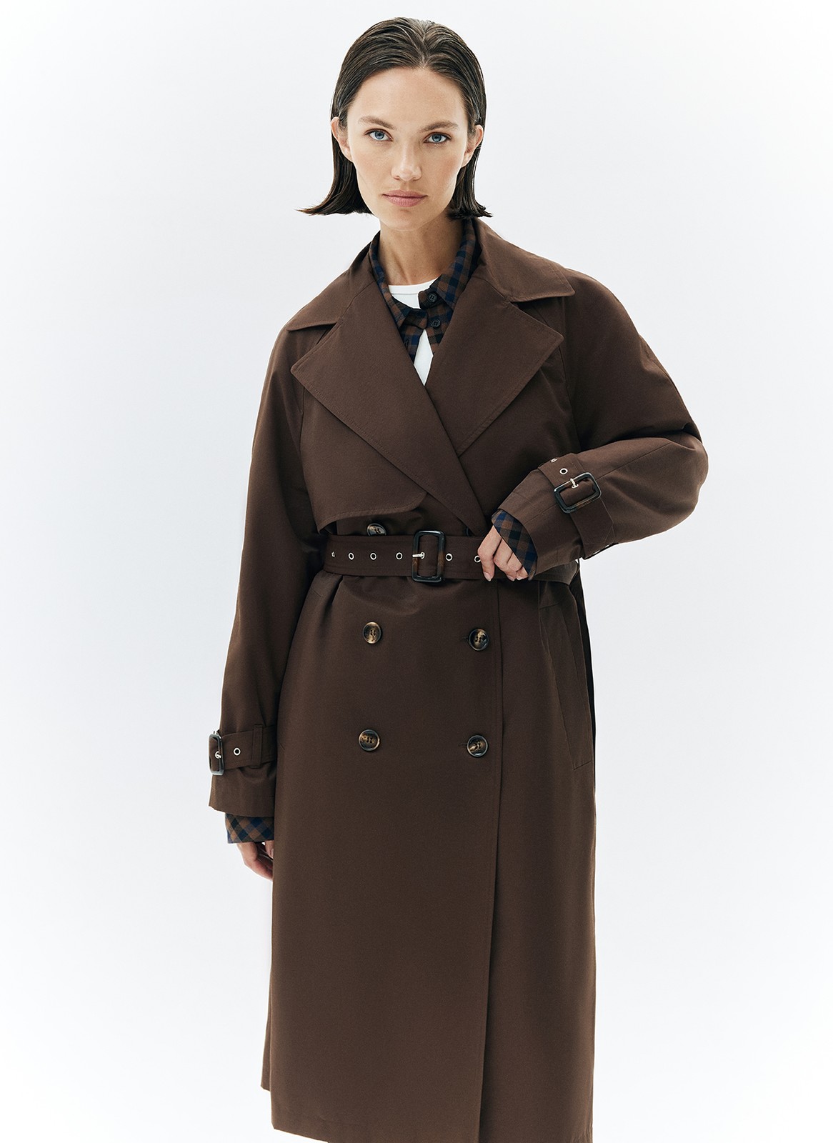 Тренч, цвет: коричневый Allweneed Плащ двубортного кроя с застёжкой на крупные контрастные пуговицы. Мы сохранили все детали классической модели: отлетную кокетку, А-силуэт, манжеты для фиксации рукава и длинный пояс на талии. Мы любим плащ за то, что с ним можно составлять женственные и универсальные повседневные образы.