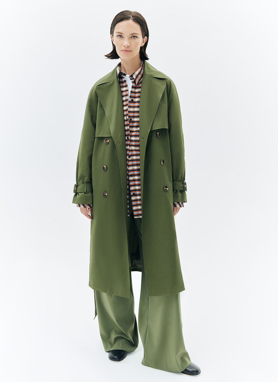 Тренч, цвет: хаки Allweneed Плащ двубортного кроя с застёжкой на крупные контрастные пуговицы. Мы сохранили все детали классической модели: отлетную кокетку, А-силуэт, манжеты для фиксации рукава и длинный пояс на талии. Мы любим плащ за то, что с ним можно составлять женственные и универсальные повседневные образы.