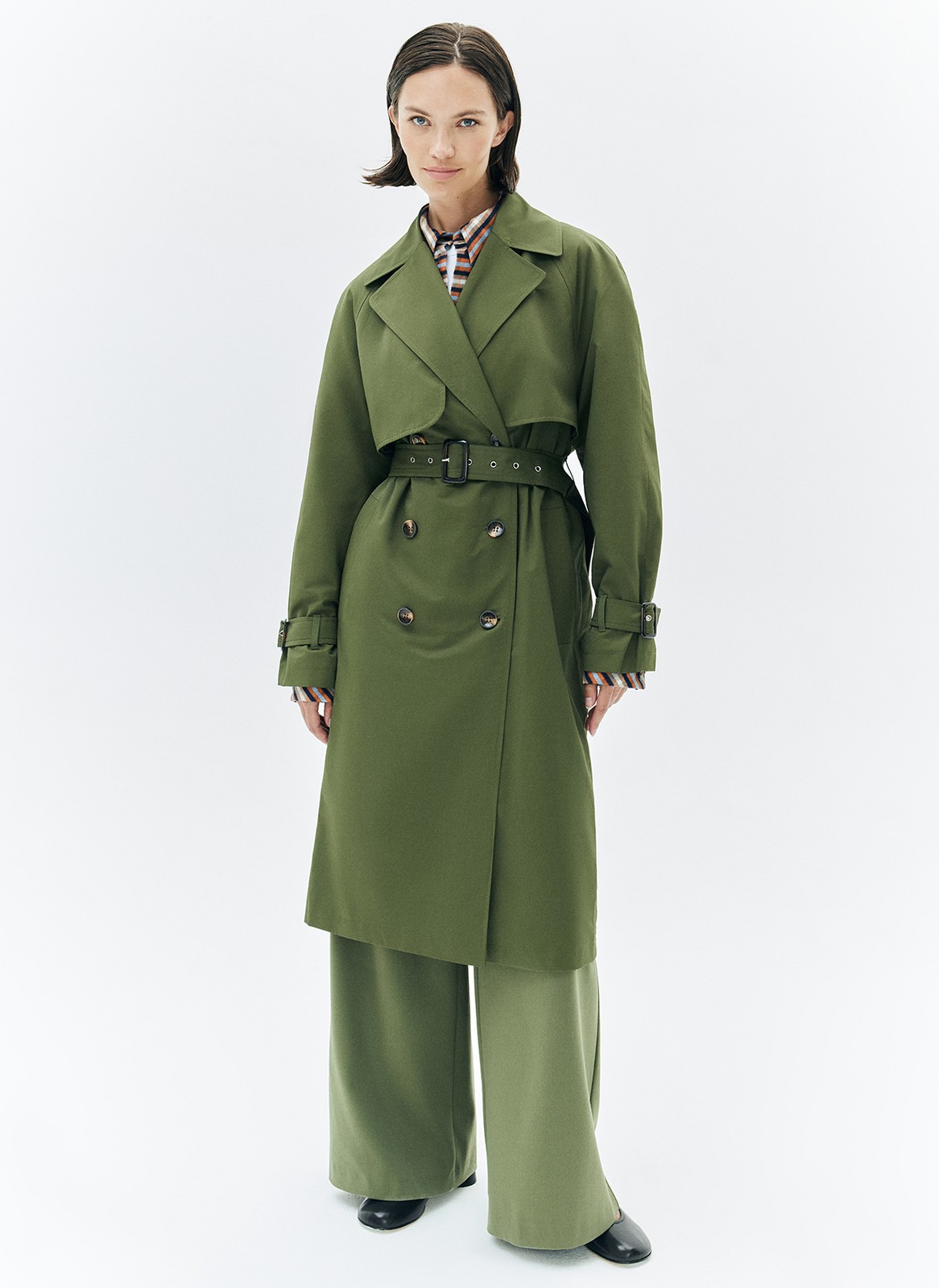 Тренч, цвет: хаки Allweneed Плащ двубортного кроя с застёжкой на крупные контрастные пуговицы. Мы сохранили все детали классической модели: отлетную кокетку, А-силуэт, манжеты для фиксации рукава и длинный пояс на талии. Мы любим плащ за то, что с ним можно составлять женственные и универсальные повседневные образы.