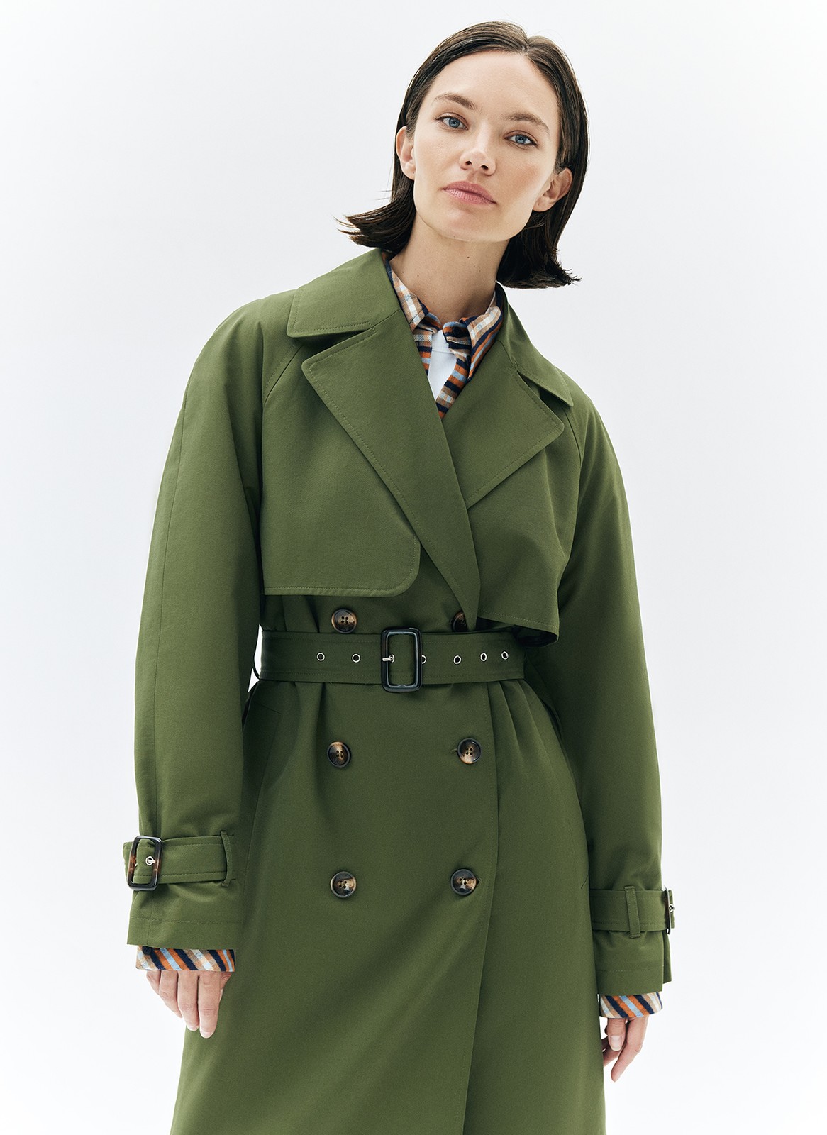 Тренч, цвет: хаки Allweneed Плащ двубортного кроя с застёжкой на крупные контрастные пуговицы. Мы сохранили все детали классической модели: отлетную кокетку, А-силуэт, манжеты для фиксации рукава и длинный пояс на талии. Мы любим плащ за то, что с ним можно составлять женственные и универсальные повседневные образы.